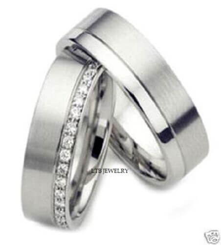 Two stylish wedding rings with a brushed finish and diamond accents, symbolizing love and commitment.