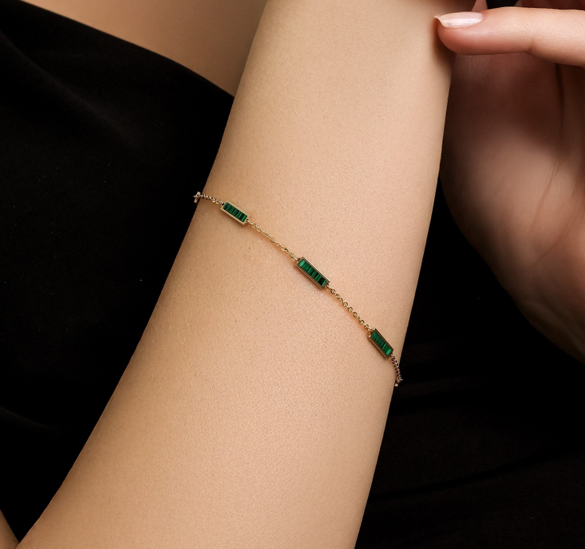 Elegant 14K solid yellow gold malachite bar bracelet on a model's wrist, showcasing a stylish design.