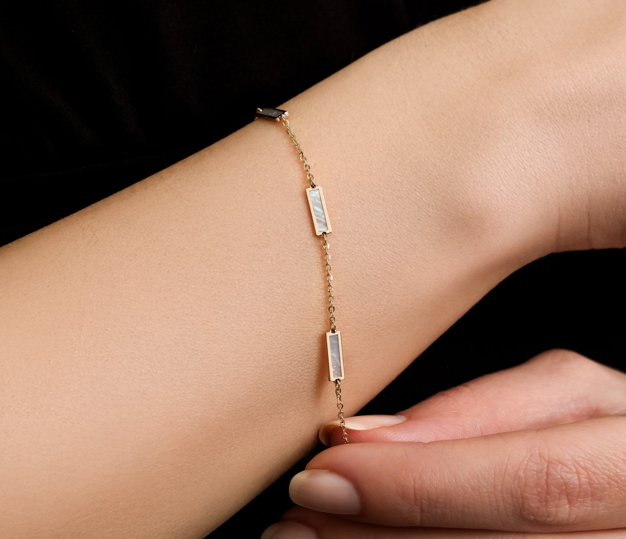 14K solid yellow gold mother of pearl bar bracelet displayed on a woman's wrist with elegant design.