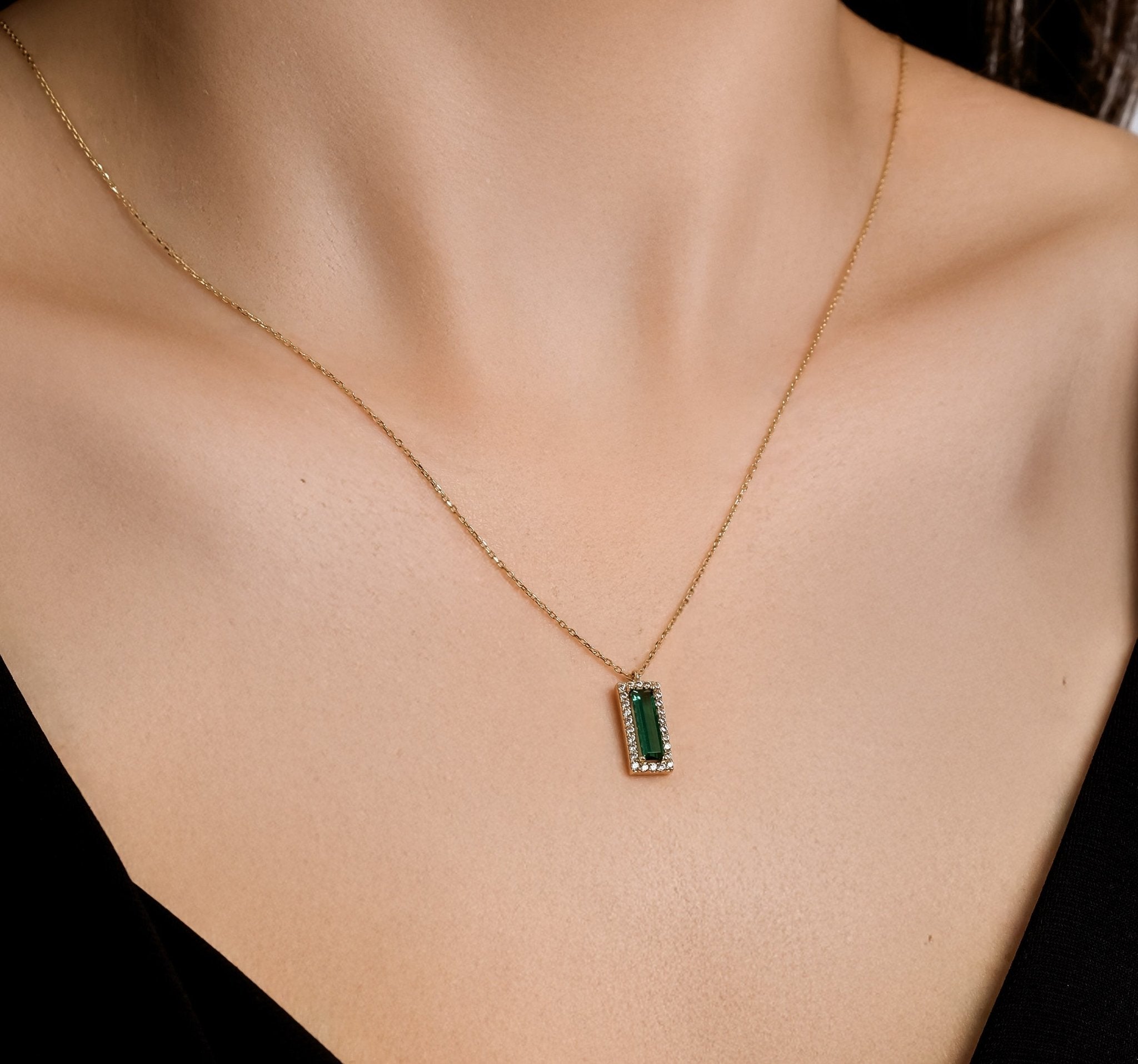 Dainty 14K solid yellow gold necklace featuring a baguette emerald pendant surrounded by cz stones.