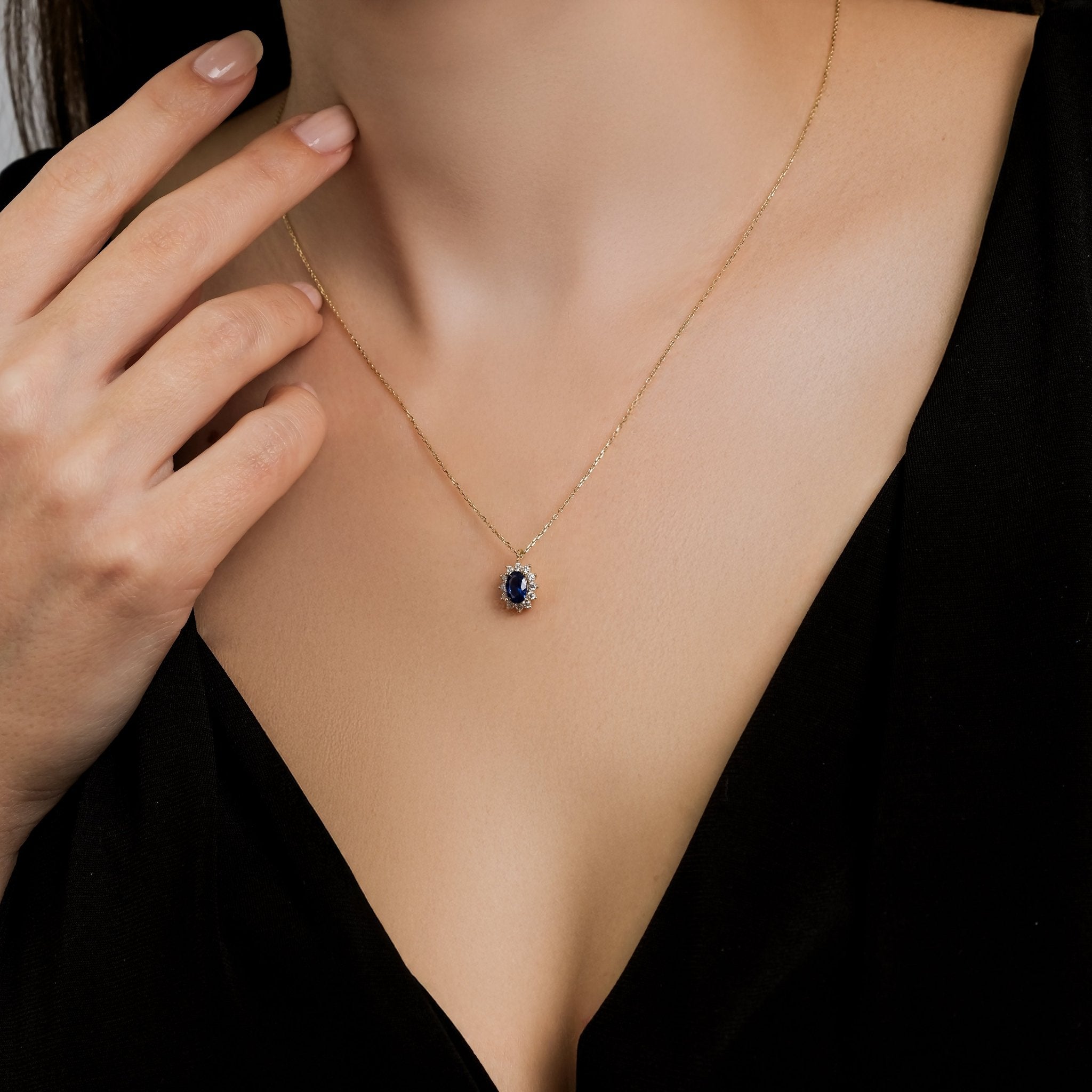 14K solid yellow gold solitaire oval sapphire necklace worn by a model, showcasing its elegance and simplicity.