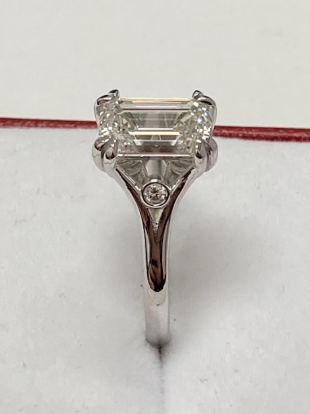 14K white gold emerald cut diamond engagement ring with side diamonds, shiny finish, IGI certified.