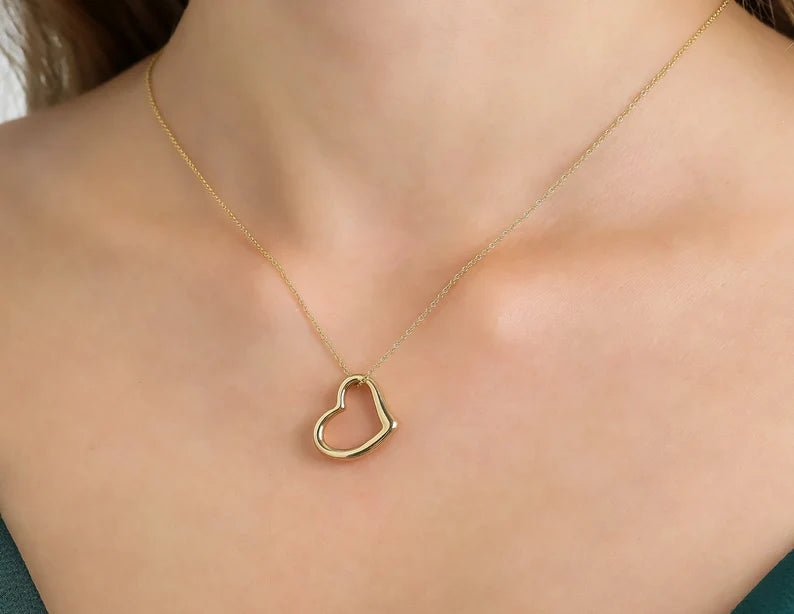 14K yellow gold heart necklace on a woman's neck, showcasing a delicate and classy design perfect for everyday wear.