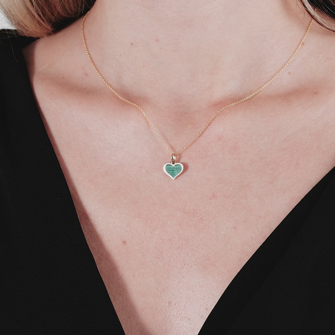 14K yellow gold malachite heart pendant necklace worn on a woman's neck, showcasing its elegant and delicate design.