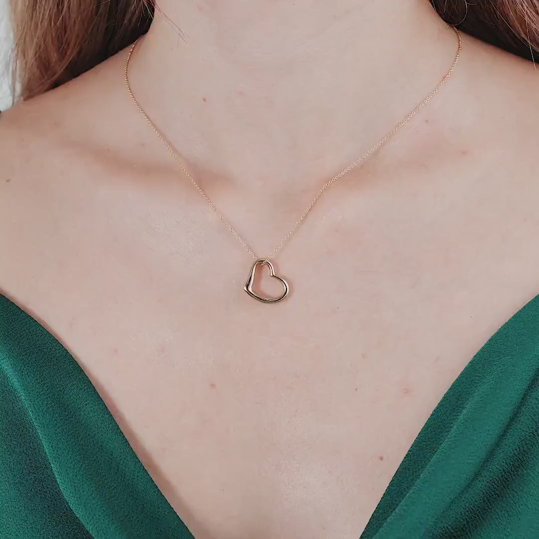 14K yellow gold heart necklace worn by a model, showcasing its delicate design and dainty charm.