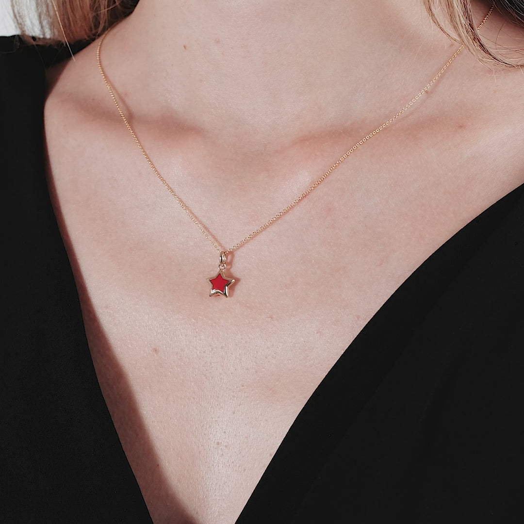 14K yellow gold coral puffed star necklace worn by a woman, showcasing a delicate design suitable for everyday use.