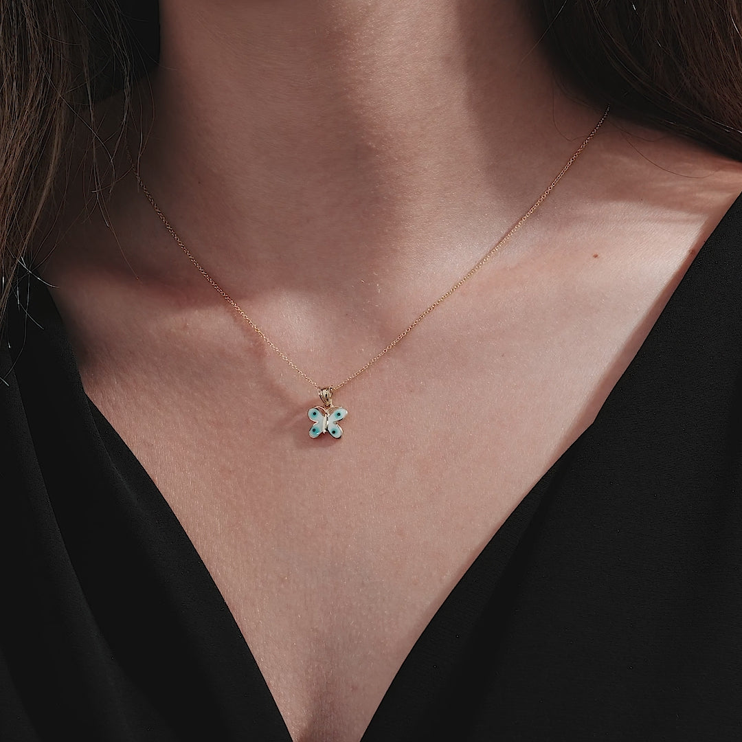14K solid yellow gold butterfly pendant necklace worn on a woman's neck, showcasing its delicate design and elegant style.
