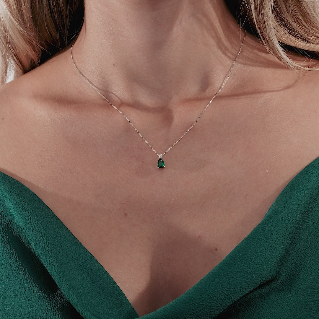 Model wearing a 14K white gold pear-shaped emerald necklace with natural diamond, showcasing elegance and sophistication.
