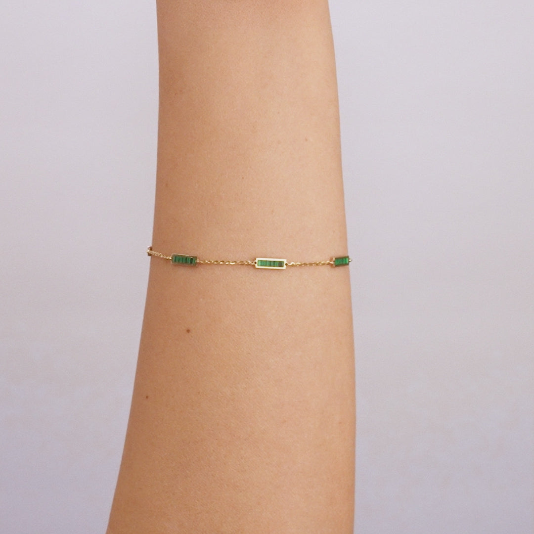 14K solid yellow gold malachite bar bracelet worn on a wrist, featuring green malachite stones and lobster claw clasp.