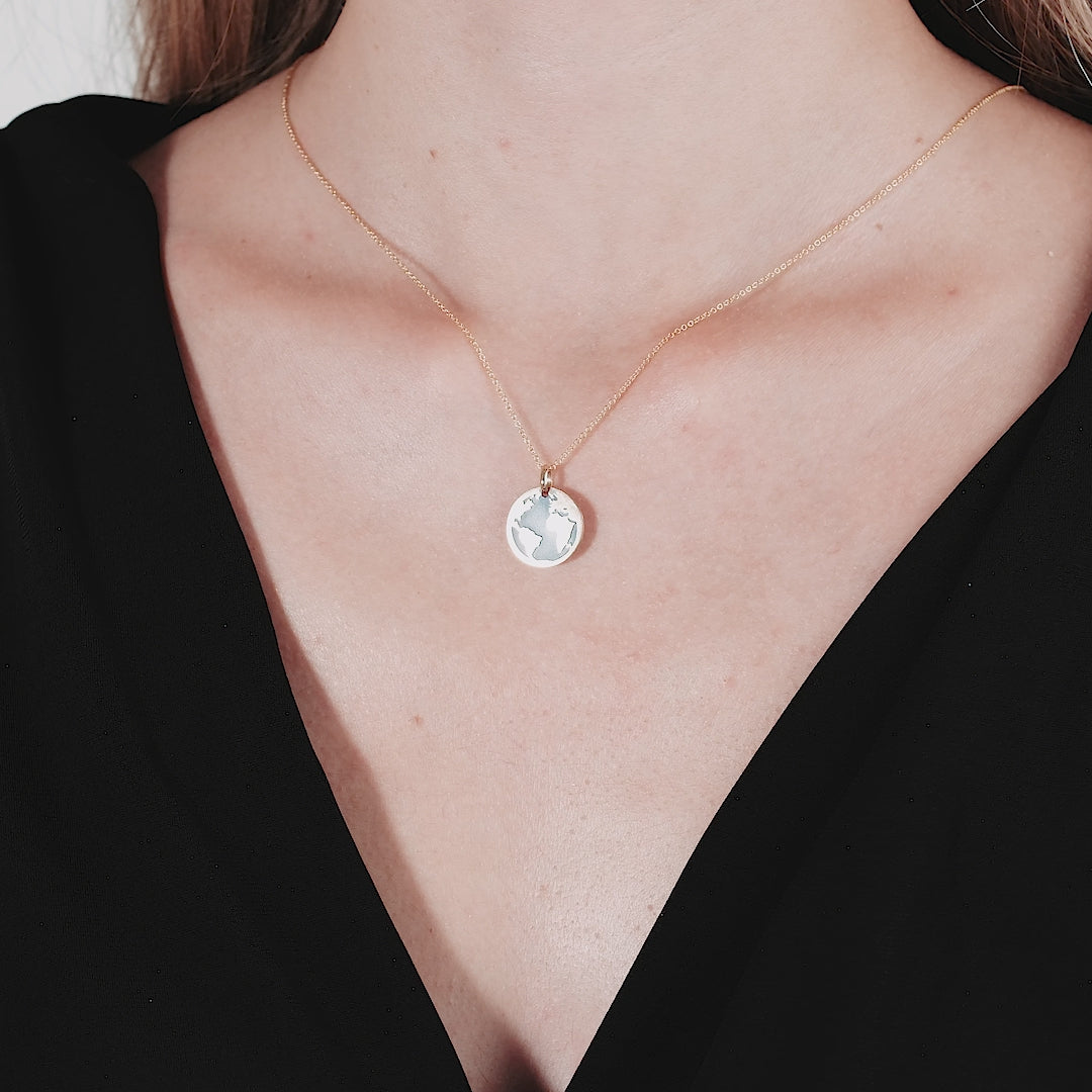 14K yellow gold lapis world map necklace showcased on a model, featuring a delicate and classy design.