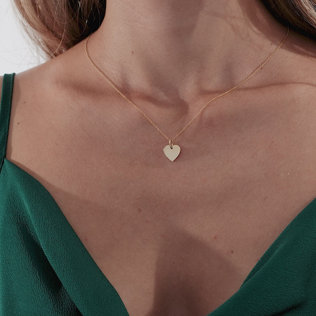 Model wearing a 14K solid yellow gold heart necklace, showcasing its delicate and minimalist design.