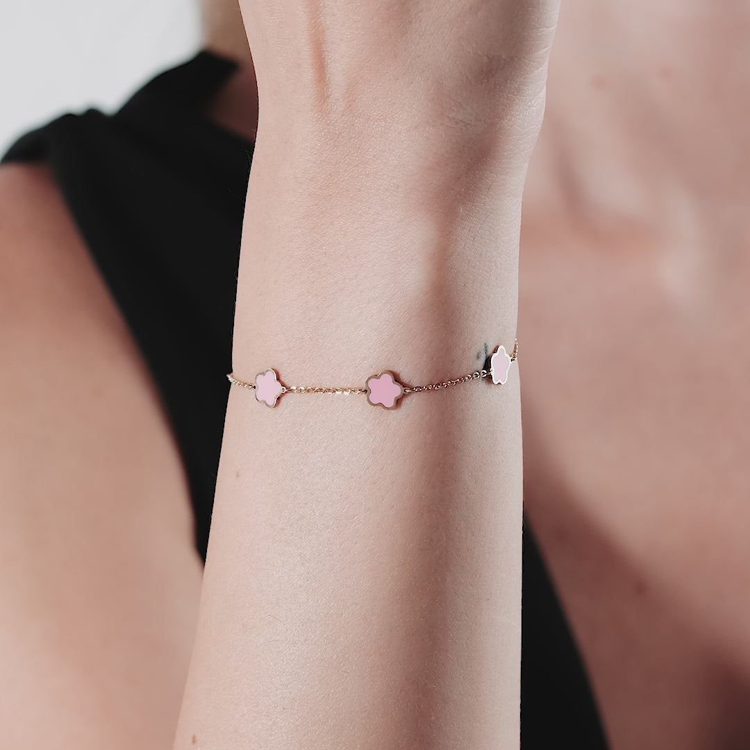 14K yellow gold bracelet featuring pink daisy blossoms, showcased on a woman's wrist.