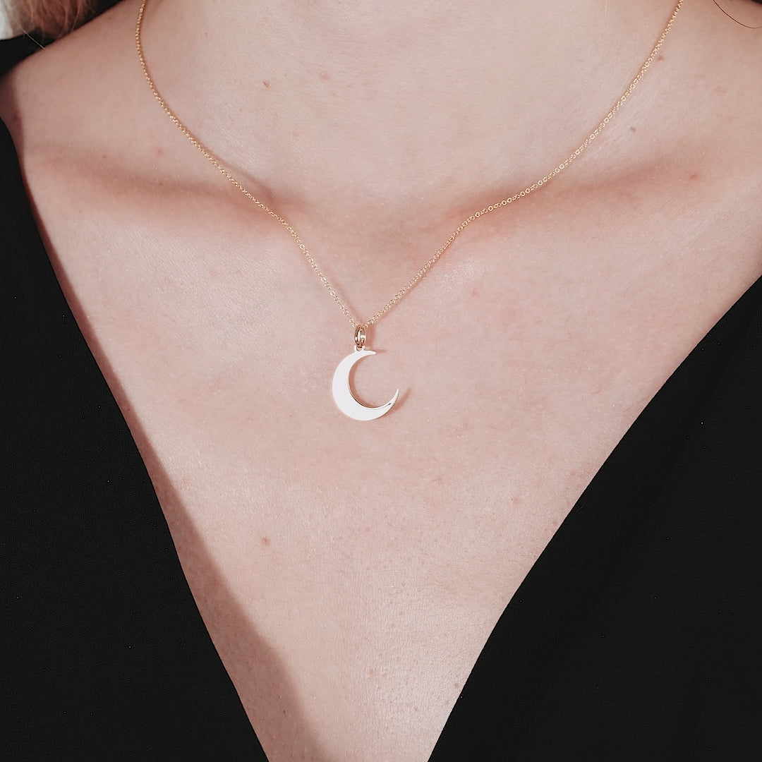 14K yellow gold crescent moon necklace featuring a natural pearl pendant, elegantly worn on a model's neck.