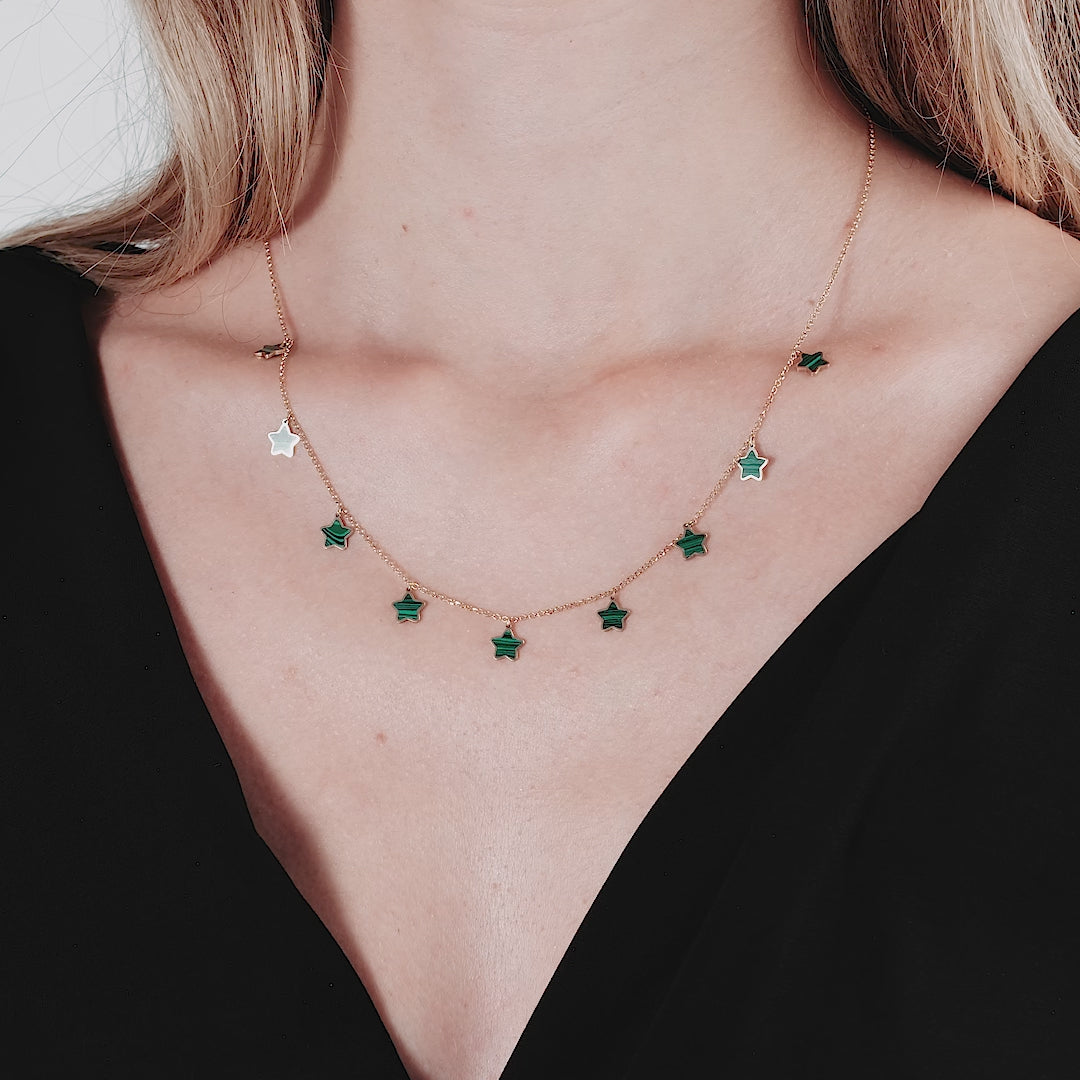 14K yellow gold station malachite star necklace with five green malachite star charms, elegantly worn on a model.