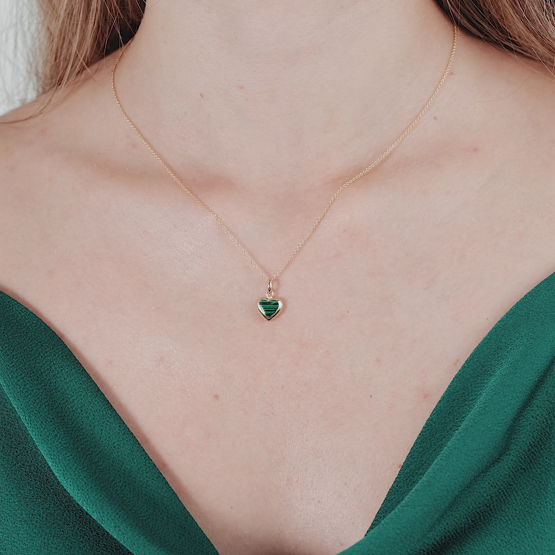 14K yellow gold malachite puffed heart pendant necklace worn by a model with a green outfit.