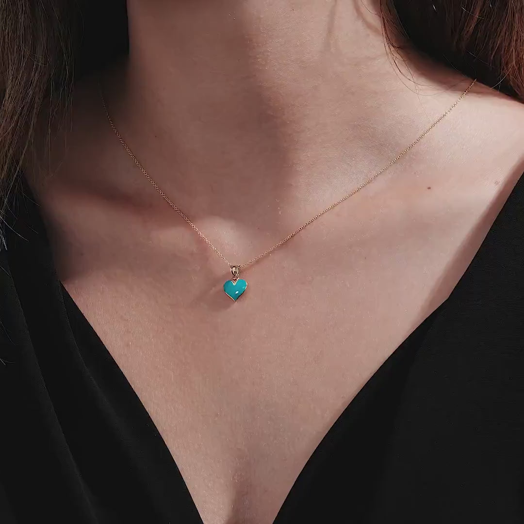 Model wearing a 14K yellow gold necklace with blue enamel heart pendant, perfect for everyday elegance.