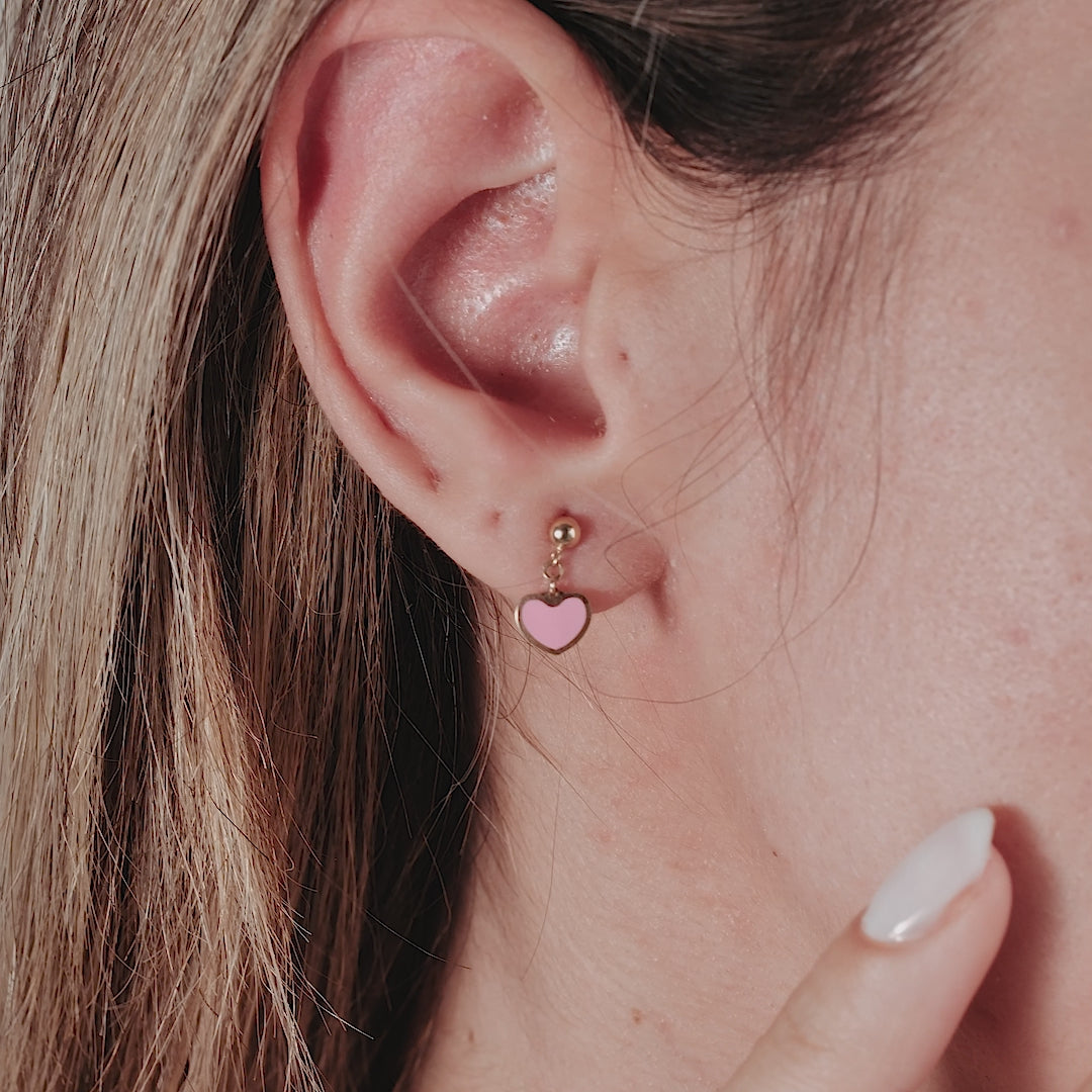 14K solid yellow gold minimalist pink heart dangle earrings worn in ear, perfect for everyday use.