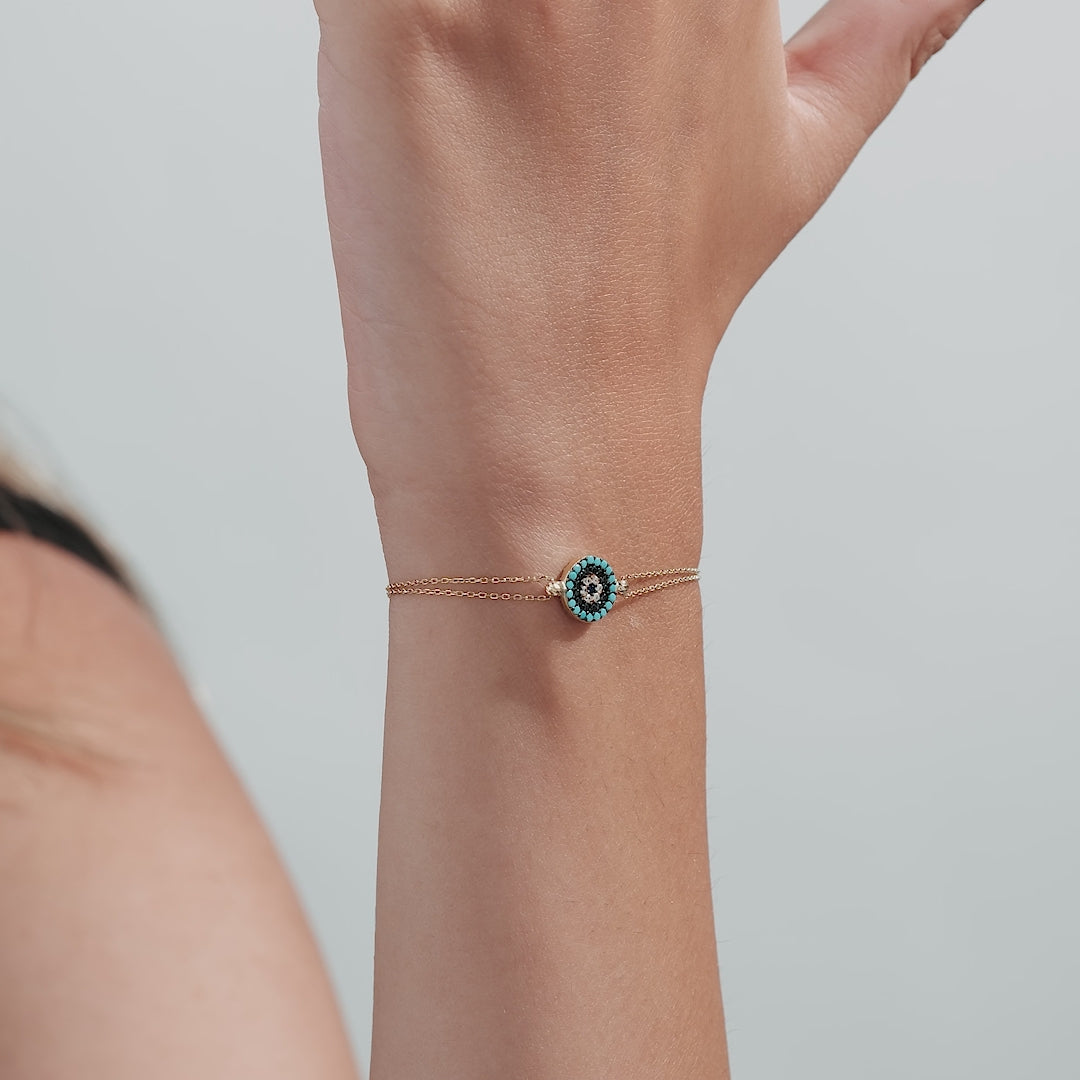 14K solid yellow gold evil eye bracelet worn on a wrist, featuring a delicate design with CZ stones.