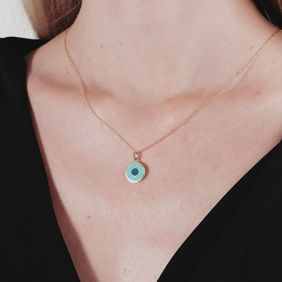 Model wearing a 14K yellow gold round turquoise evil eye necklace, featuring a delicate design, perfect for everyday use.