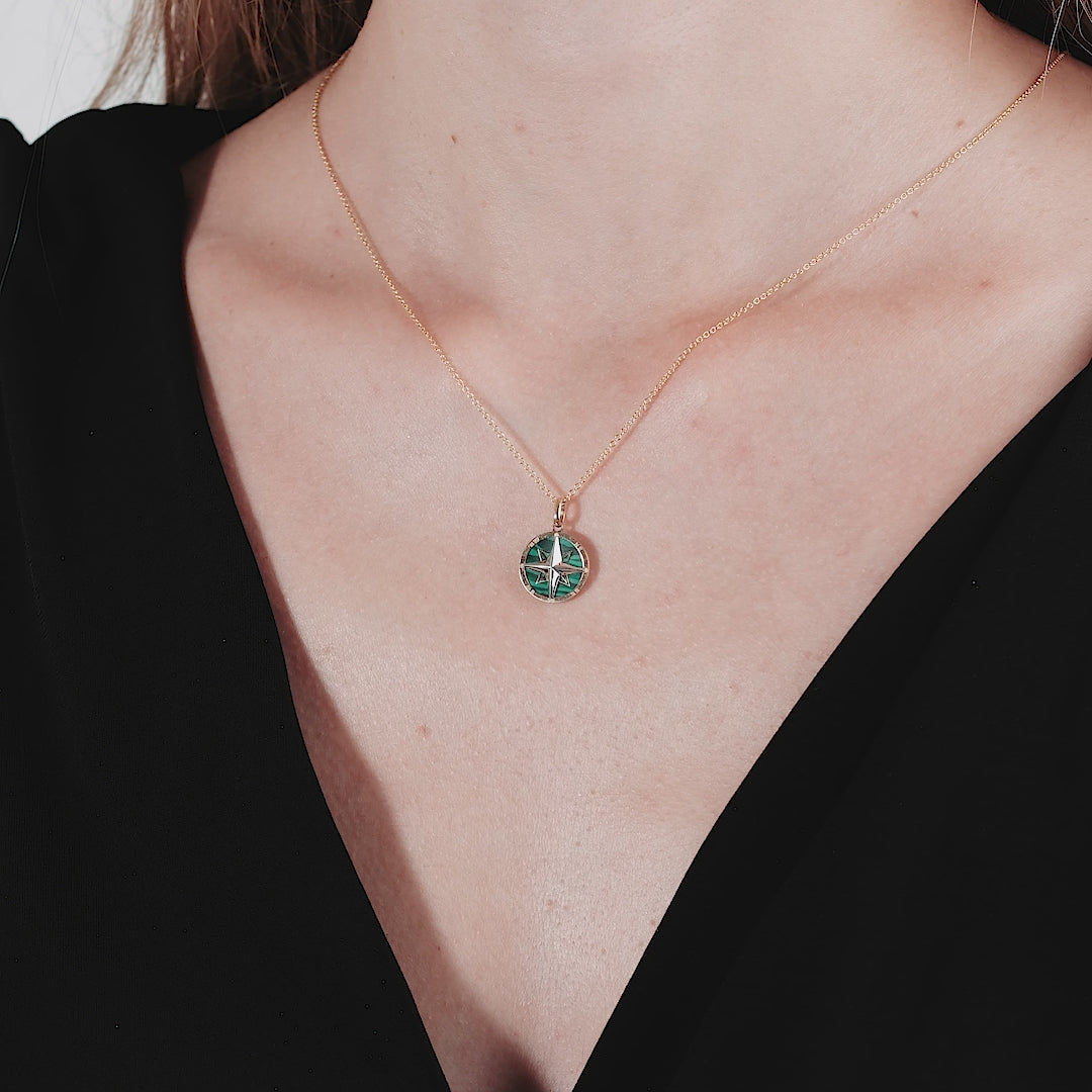 14K yellow gold malachite compass necklace worn, showcasing its delicate design and vibrant green color.
