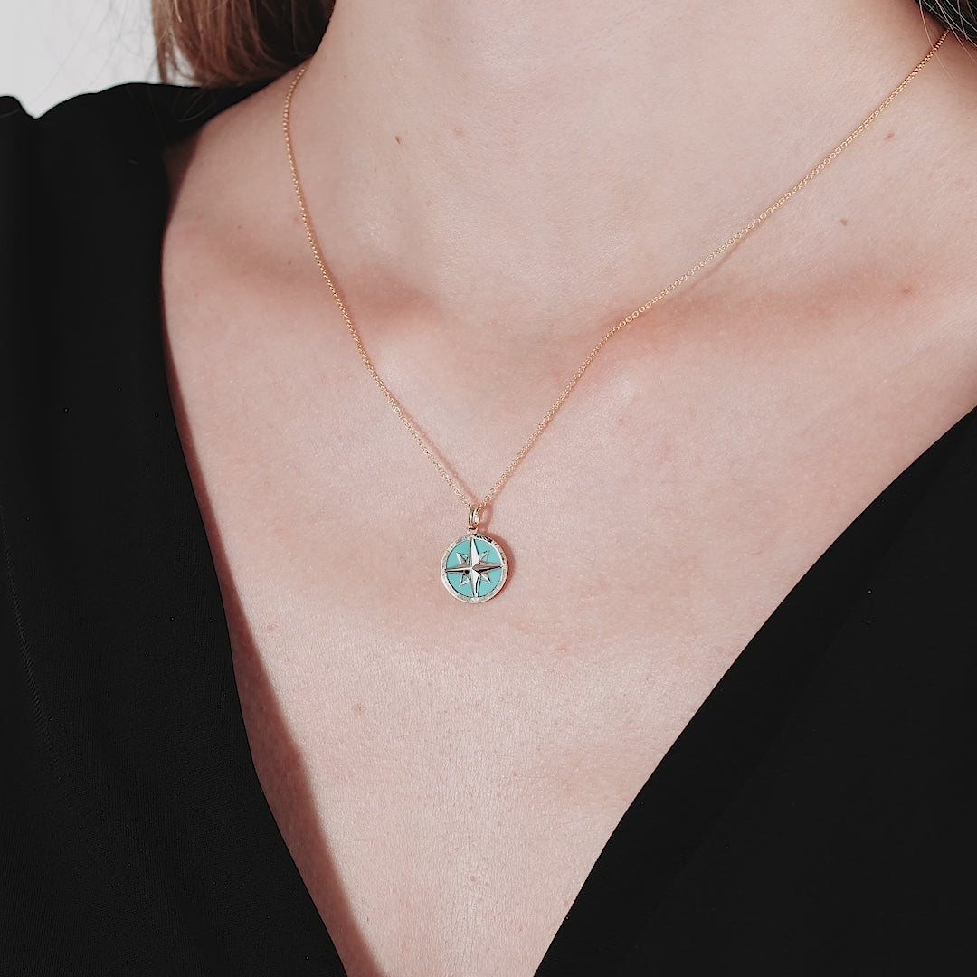 14K yellow gold turquoise compass necklace worn by a model, showcasing its dainty design and vibrant colors.