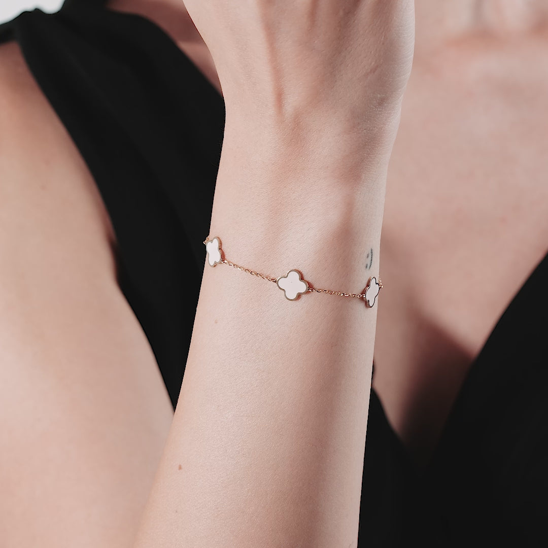 14K solid yellow gold pink four leaf clover bracelet worn on wrist, showcasing elegant design and delicate chain.