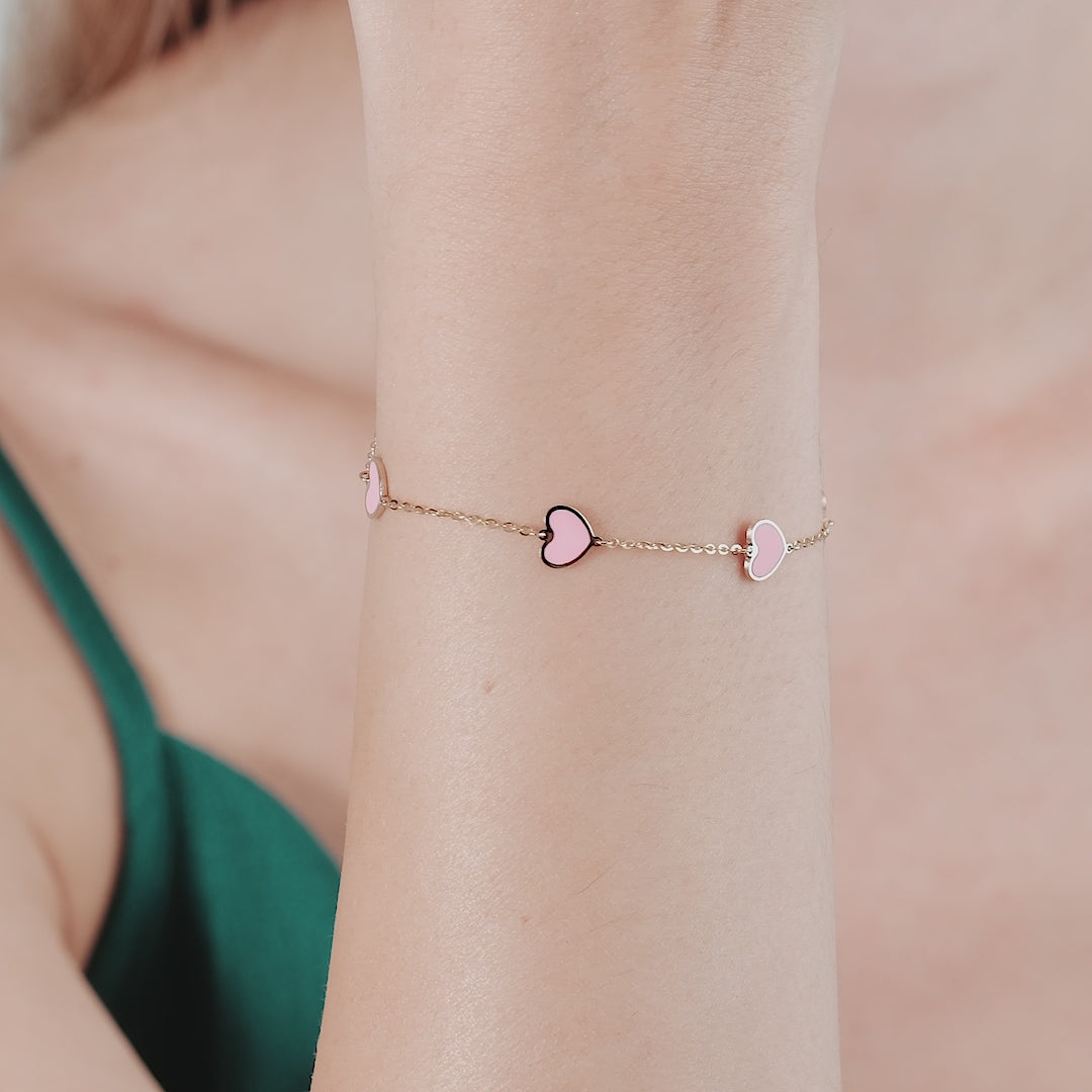 14K solid yellow gold bracelet with pink heart charms, showcasing a stylish design and elegant look.