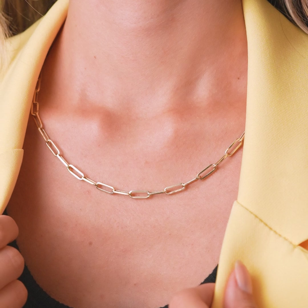 14K yellow gold 4.5mm paperclip necklace worn by woman in a yellow blazer, showcasing its elegance and simplicity.