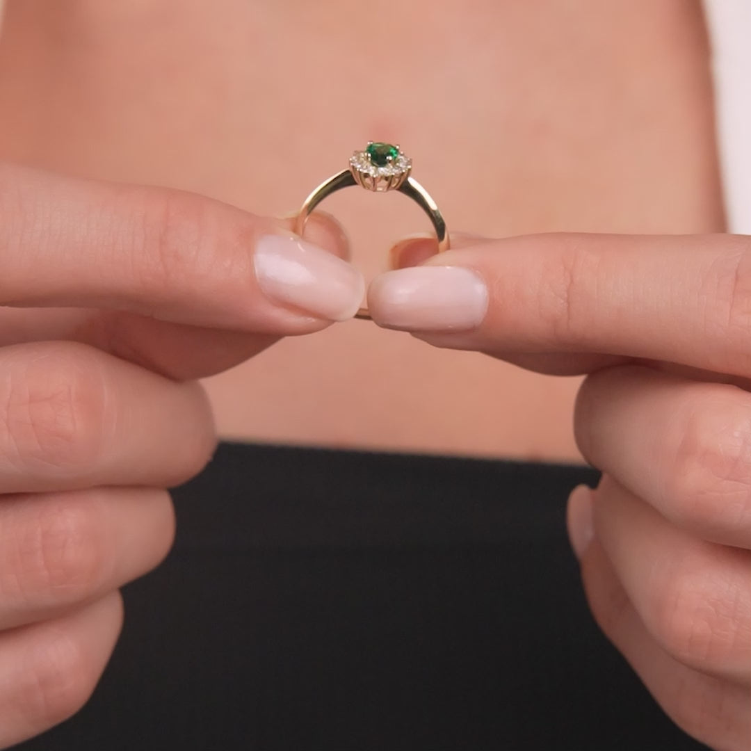 14K yellow gold pear shape emerald ring with CZ held between two fingers, stunning women's jewelry.