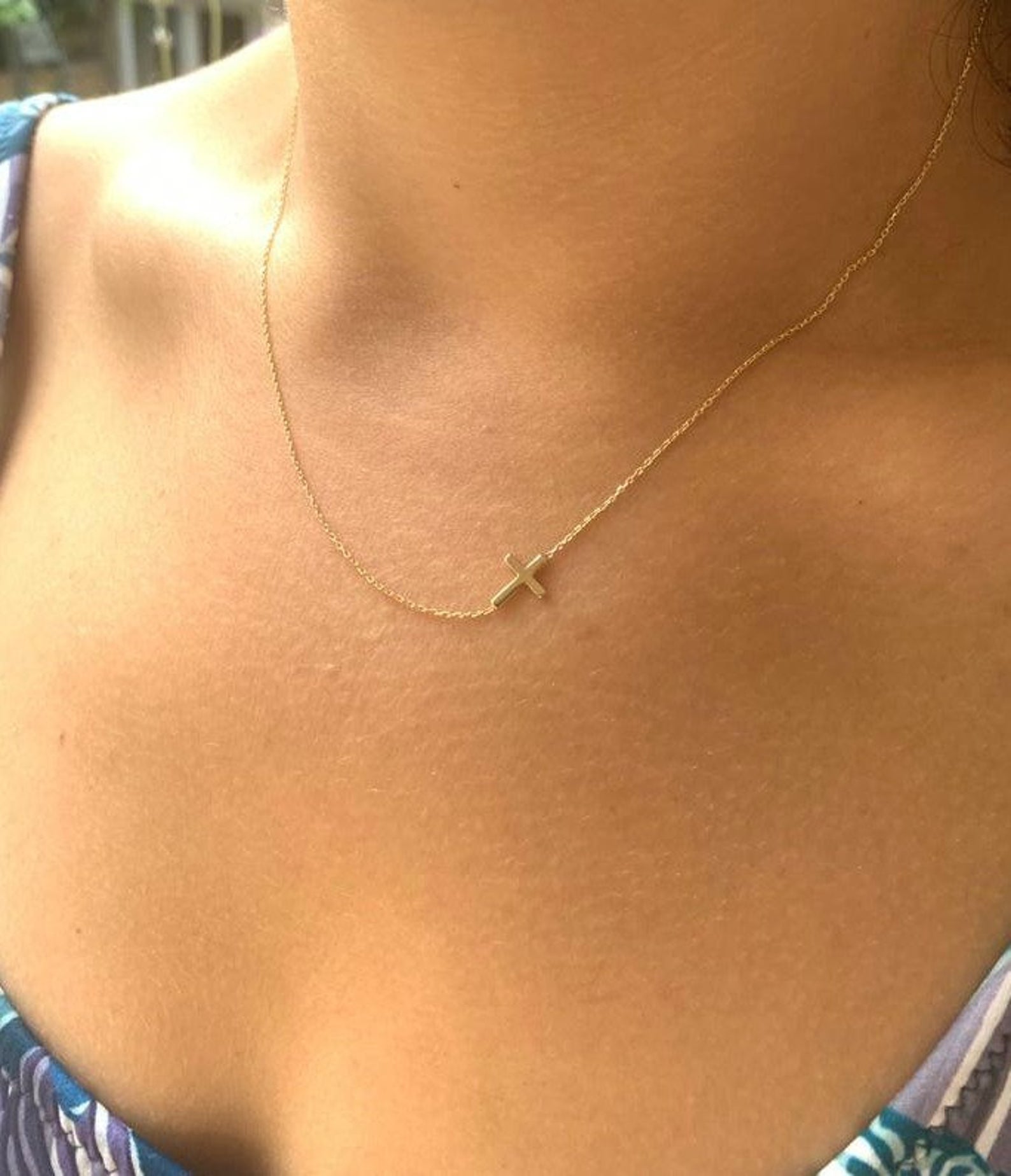 14K solid yellow gold minimalist sideways cross necklace displayed on a model's neck, perfect for everyday elegance.