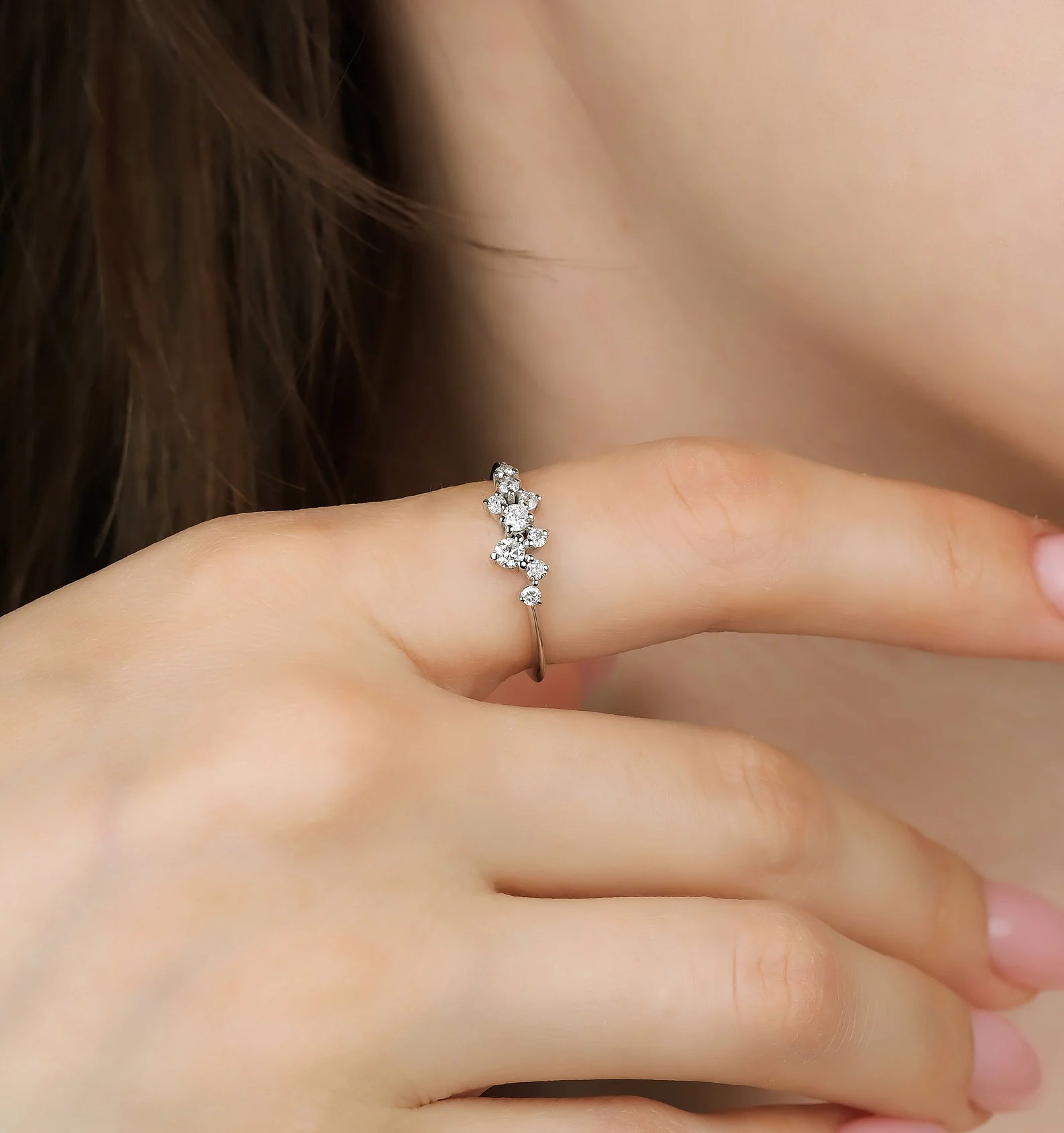 14K gold diamond cluster ring worn on a hand, showcasing delicate design with sparkling round diamonds.