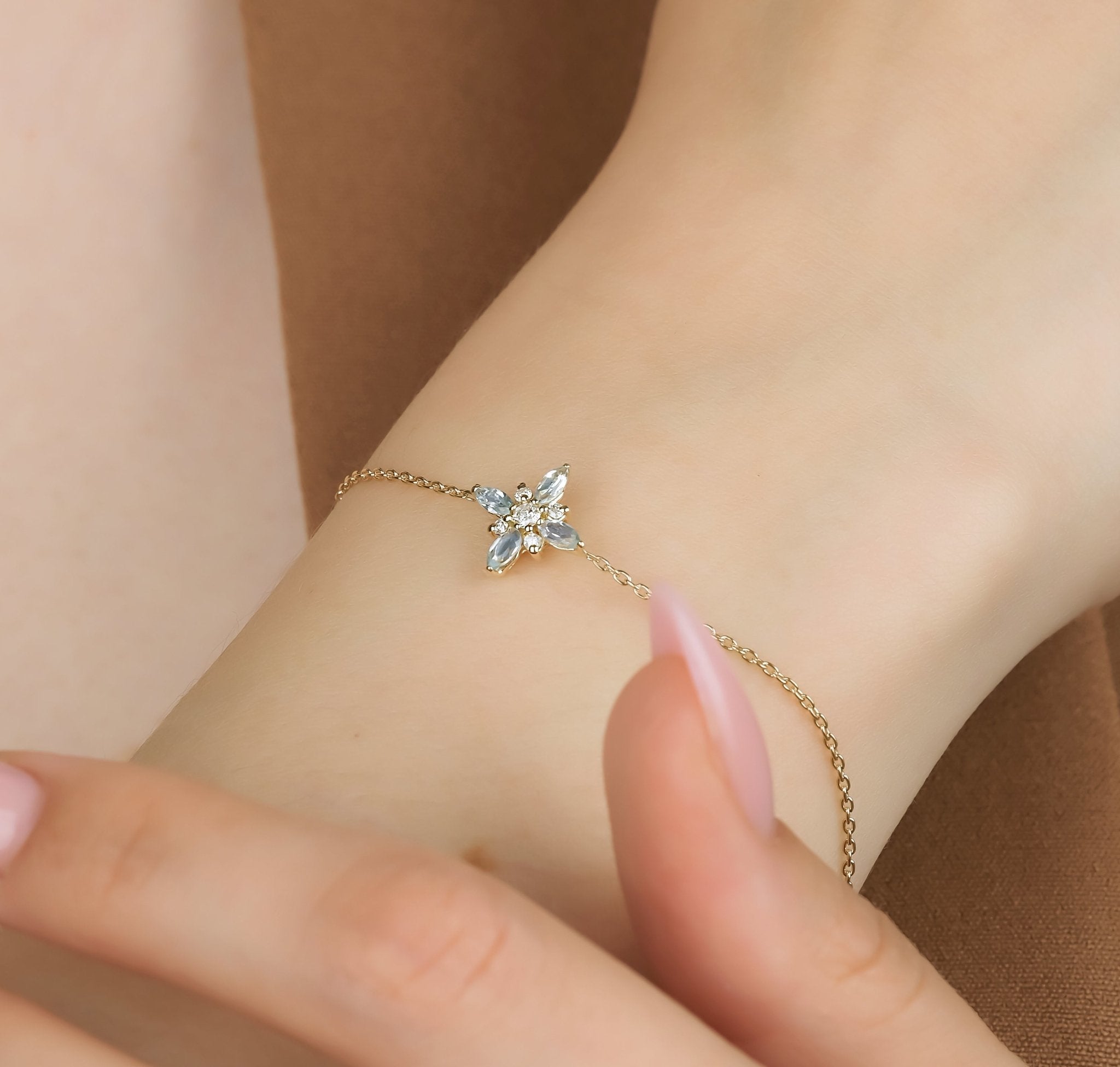 Delicate 14K gold marquise topaz and diamond bracelet worn on wrist, showcasing natural gemstones.