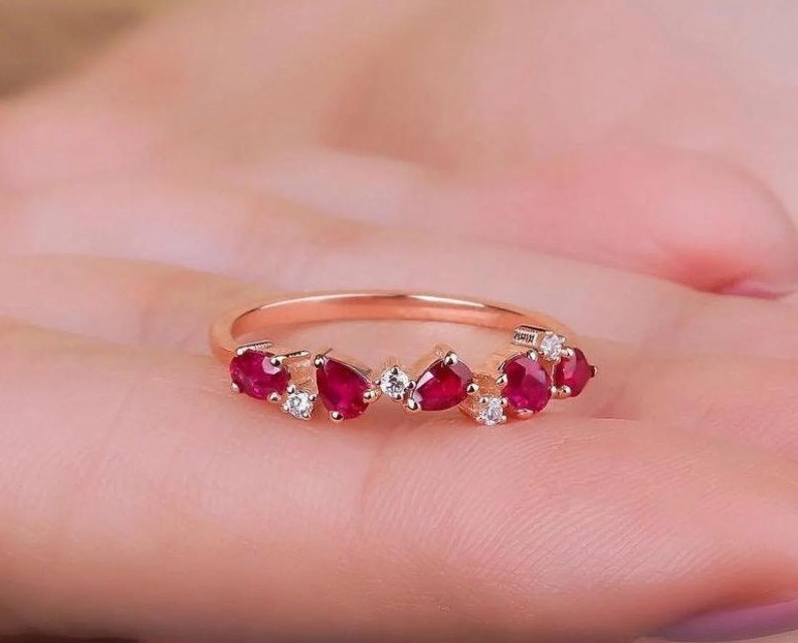 14K gold ring with pear-shaped rubies and diamonds, displayed on a hand, perfect for elegant occasions.