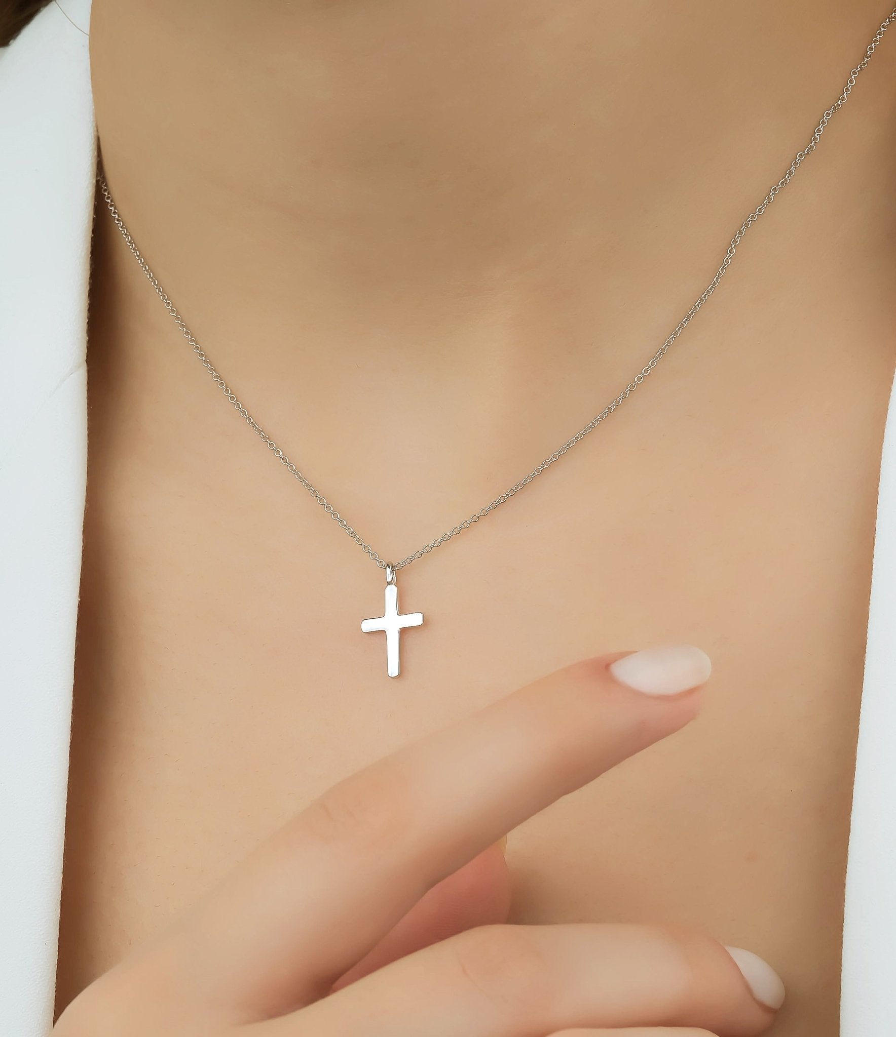 Minimalist 14K solid white gold cross necklace worn elegantly, showcasing dainty design and fine craftsmanship.