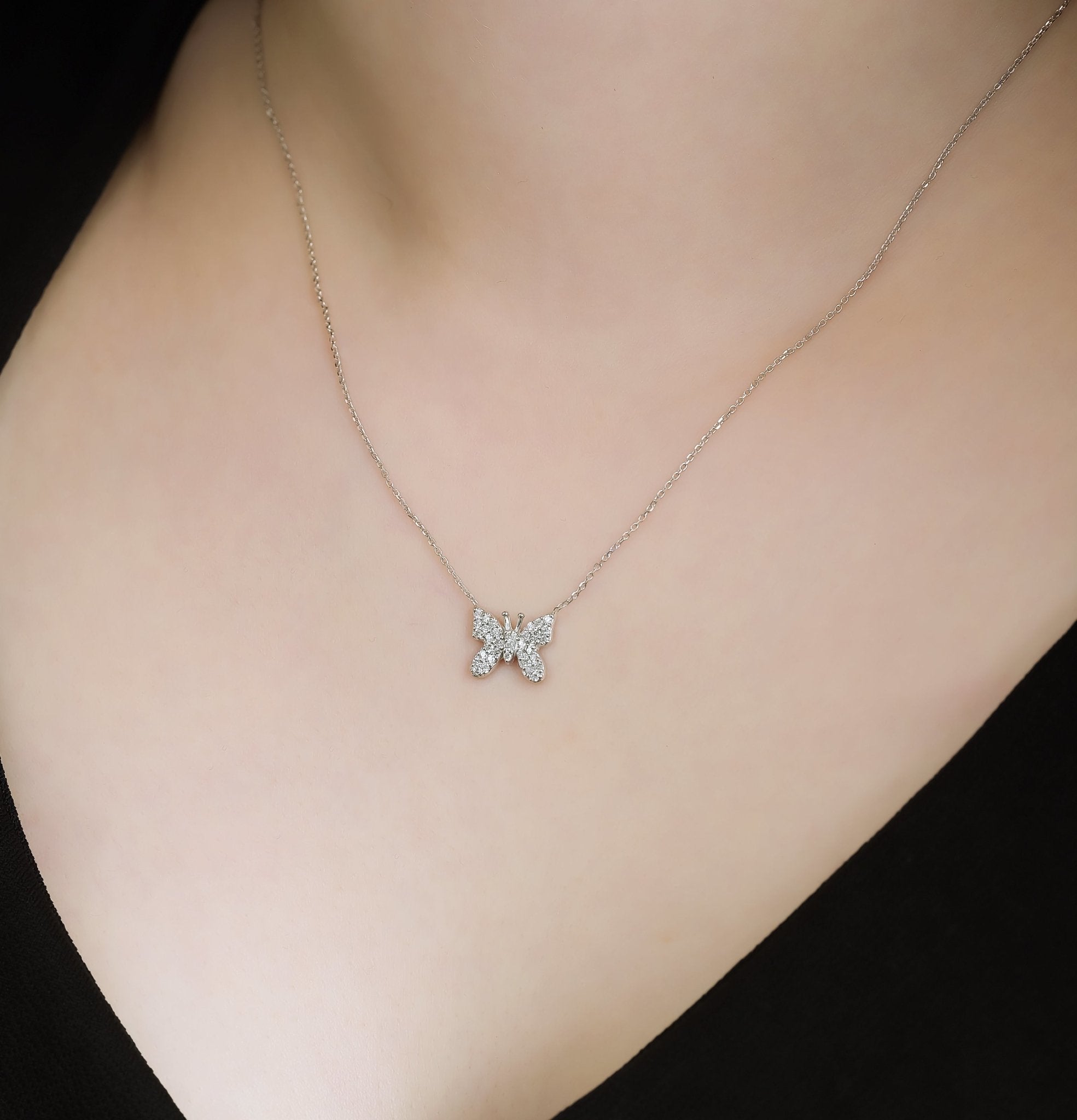 14K solid white gold butterfly necklace adorned with 35 sparkling diamonds, elegantly displayed on a model.