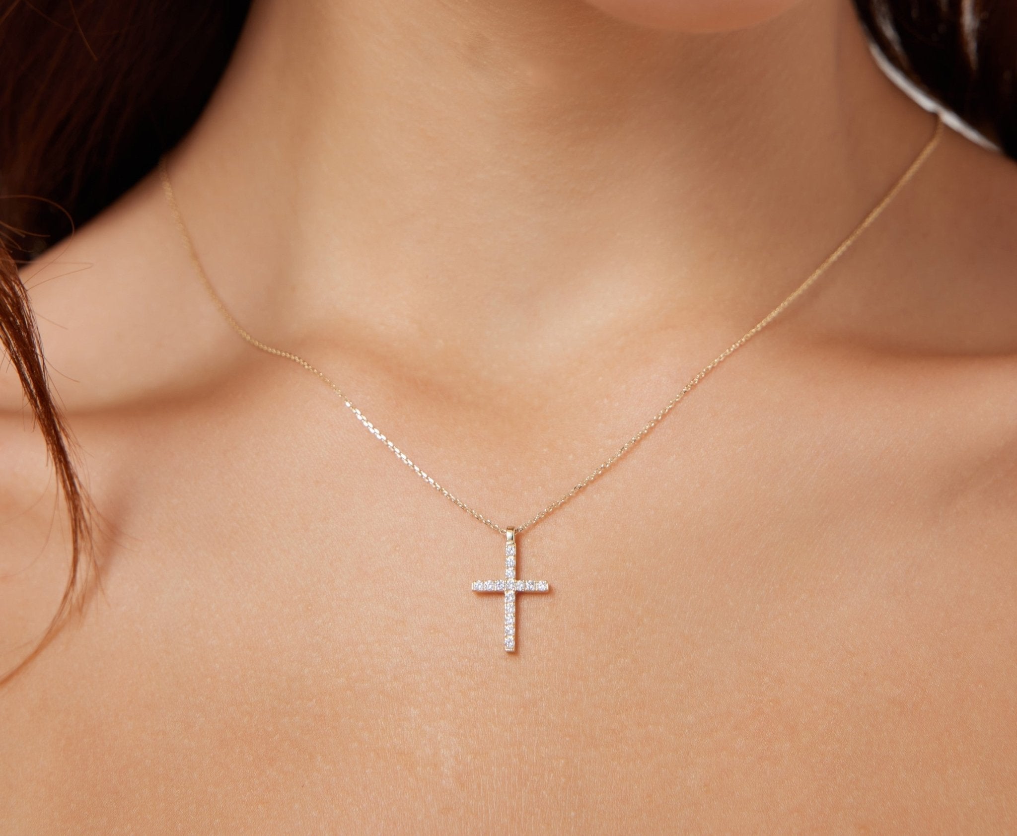 14K solid white gold diamond cross necklace worn on a woman's neck, showcasing its elegant design and sparkling diamonds.