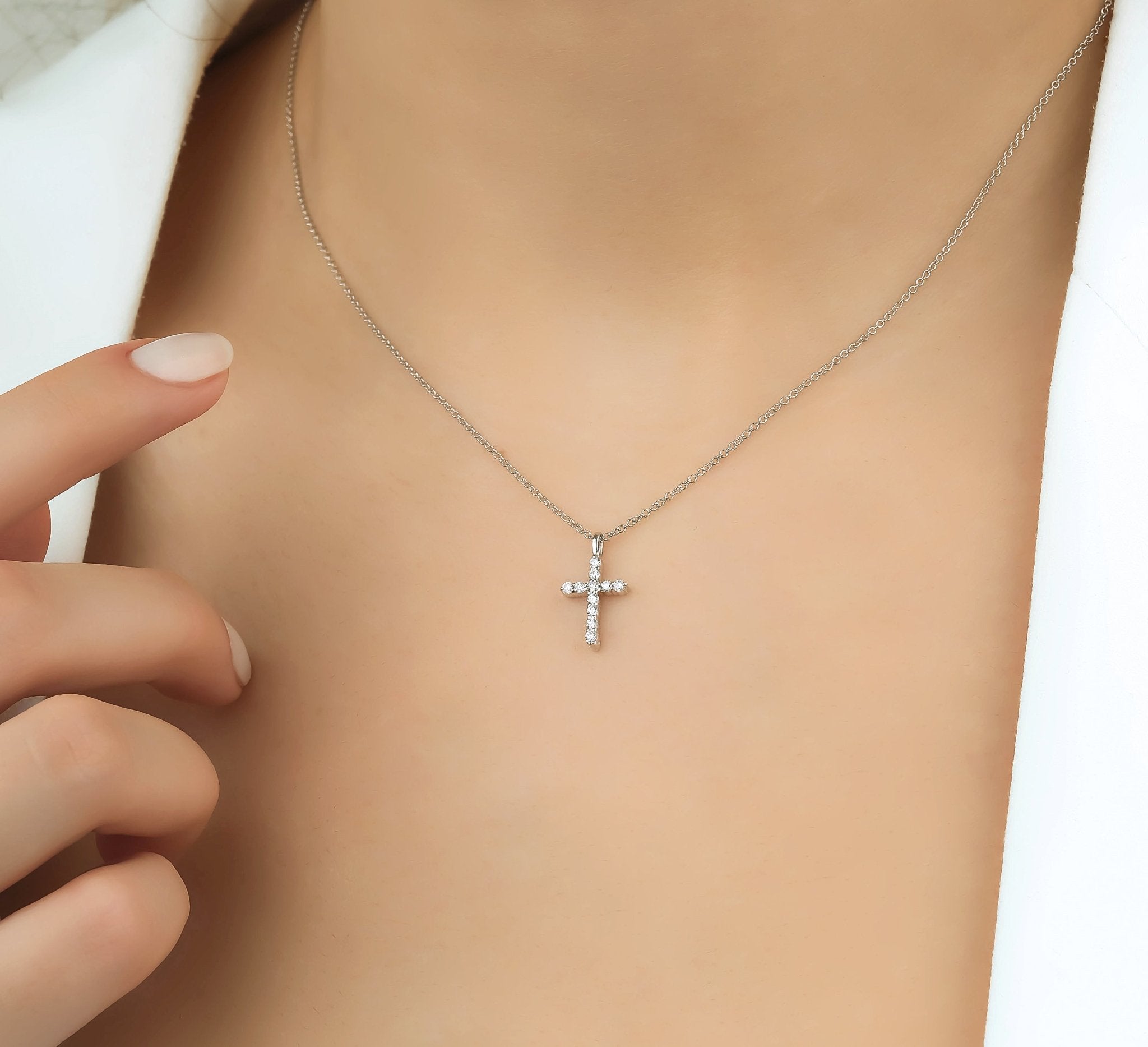 14K solid white gold diamond cross necklace worn by a model, showcasing its elegant and minimalist design.