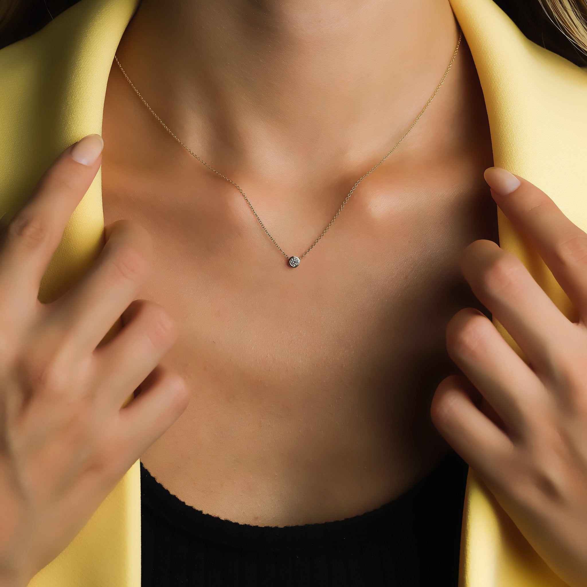 Model wearing a 14K solid white gold 0.12 carat diamond solitaire necklace, showcasing its minimalist design.