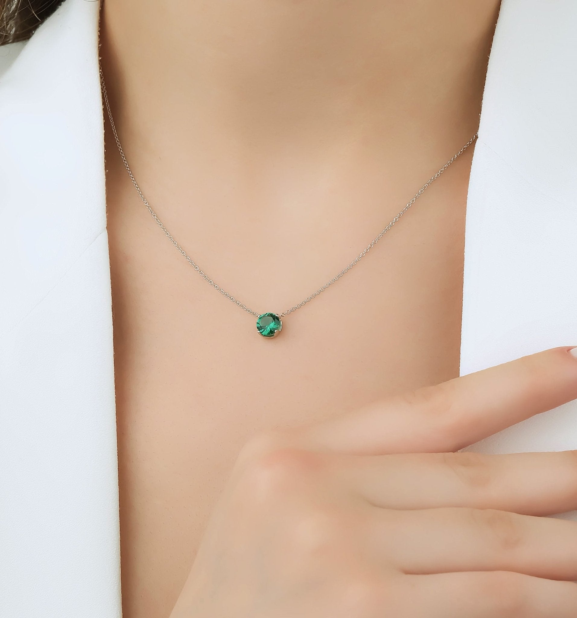 Dainty 14K white gold prong setting 6mm emerald solitaire necklace on model, perfect for everyday wear.