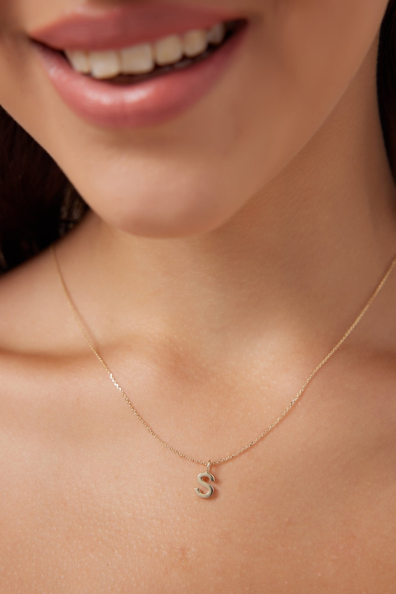 14K solid white gold initial necklace featuring letter S, worn by woman, delicate design, perfect for personalized jewelry.