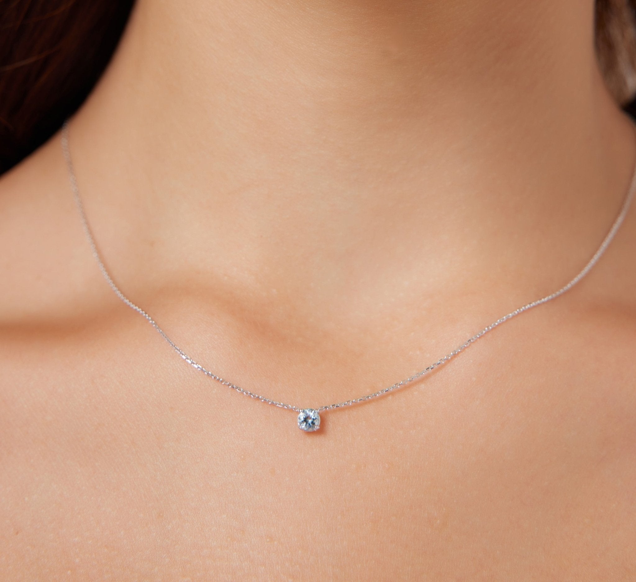 14K yellow gold 5mm prong setting solitaire aquamarine necklace worn on neck, perfect minimalist jewelry for everyday use.