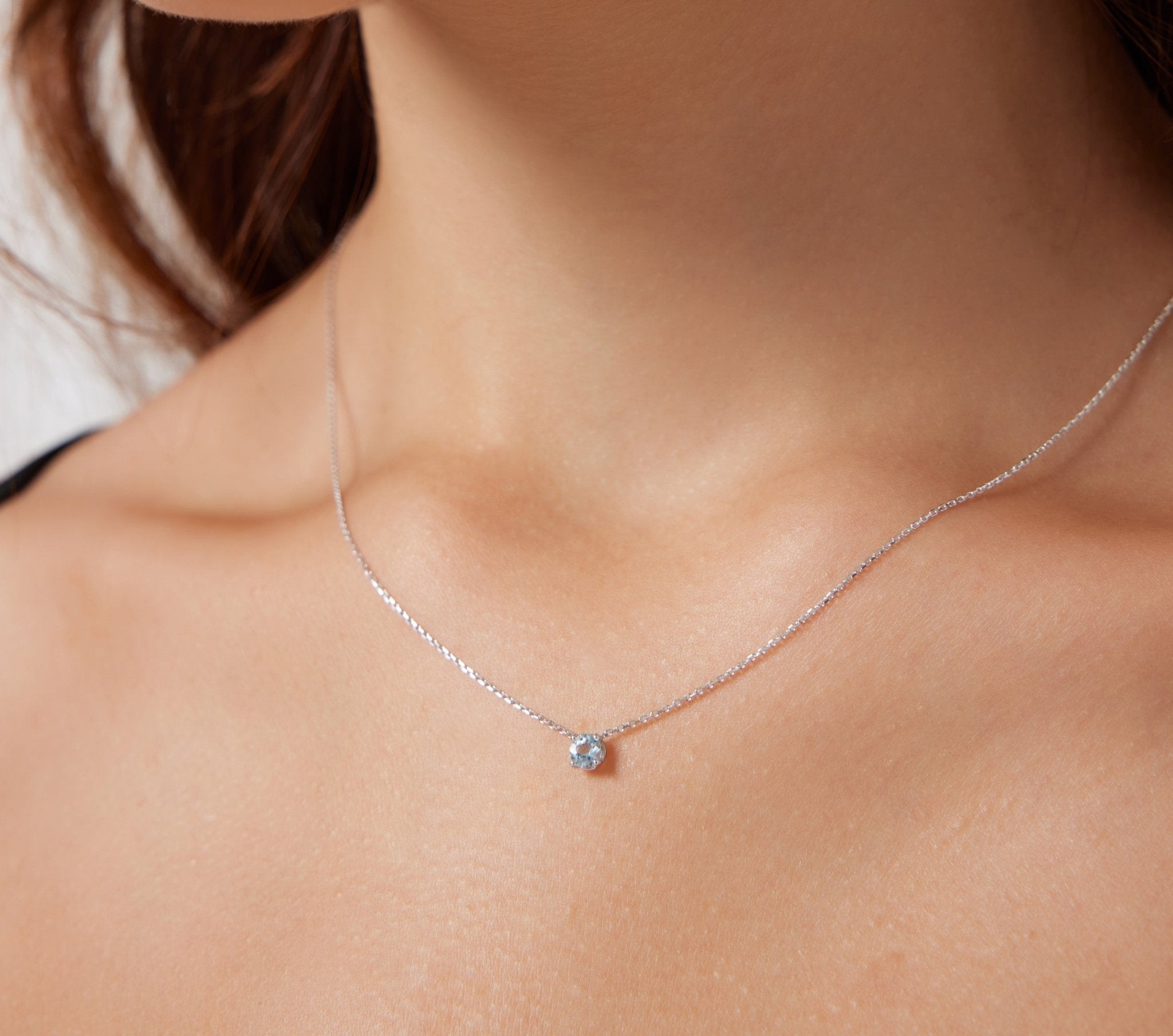 14K yellow gold prong setting solitaire aquamarine necklace worn by model, showcasing 5mm gemstone on a delicate chain.