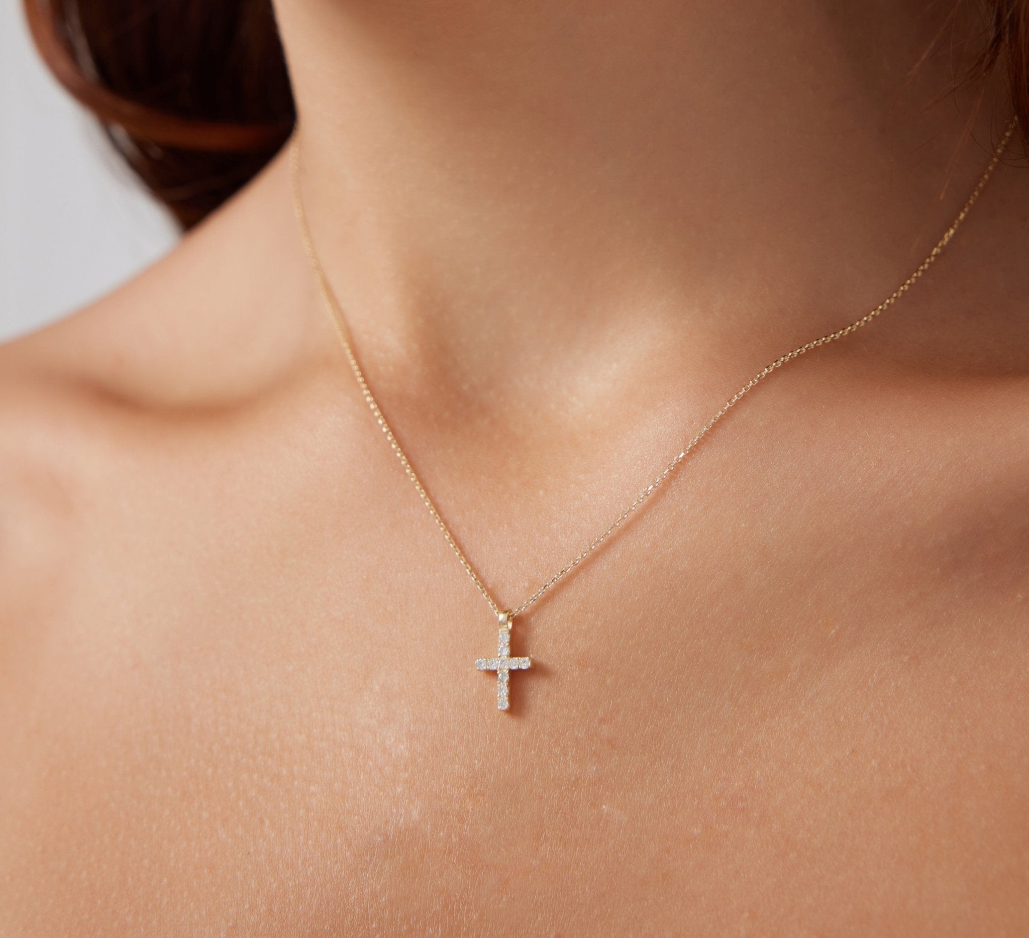 14K solid white gold minimalist diamond cross necklace worn on a model's neck, showcasing elegance and simplicity.
