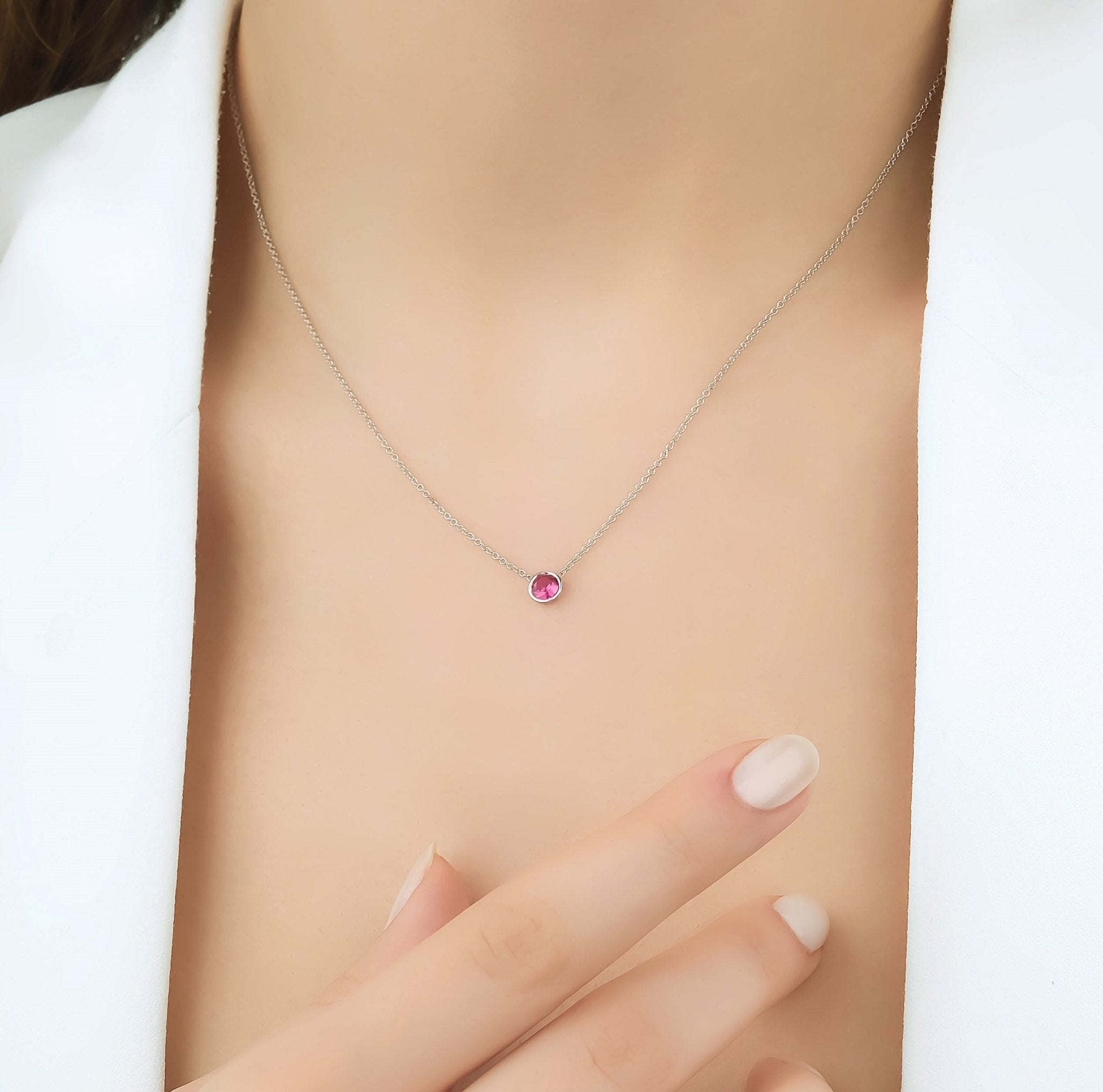 14K white gold 4mm bezel set ruby solitaire necklace worn, perfect for July birthstone jewelry.