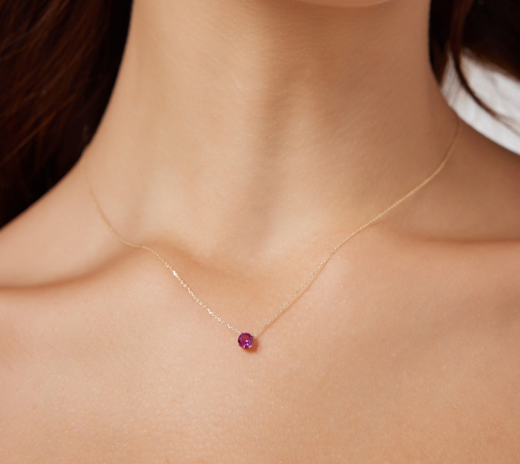 Dainty 14K white gold 5mm prong setting solitaire ruby necklace worn on a model's neck, ideal for July birthdays.