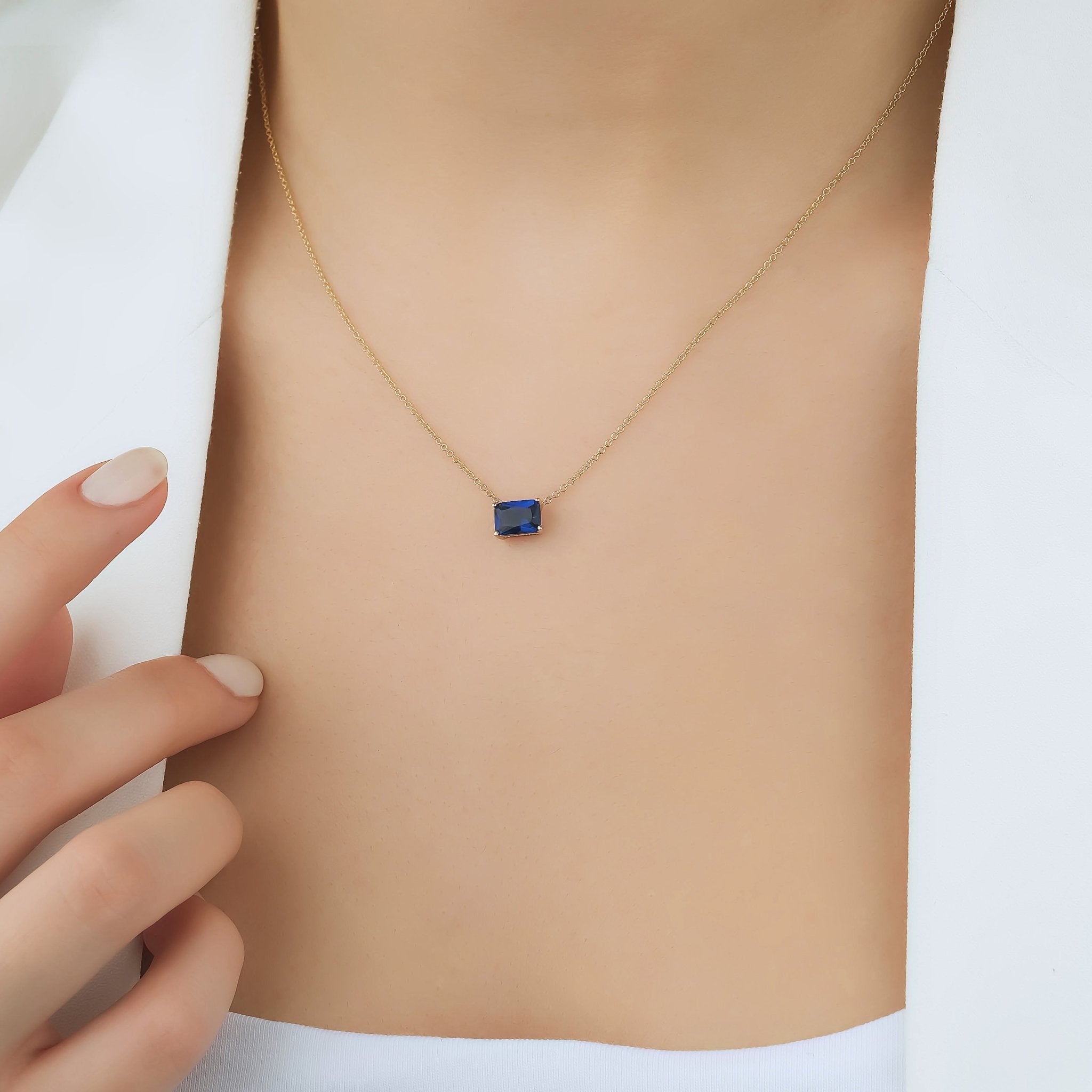 Elegant emerald cut sapphire solitaire necklace in 14K white gold, perfect for everyday wear and minimalist style.