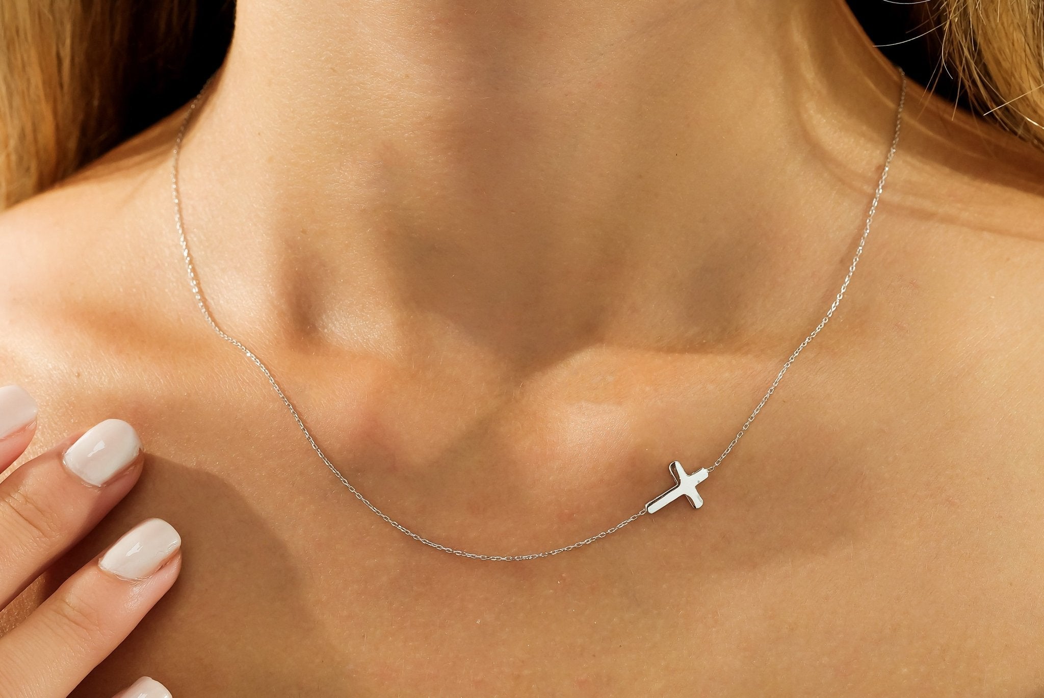 14K solid white gold minimalist sideways cross necklace worn on a model's neck, showcasing elegance and simplicity.