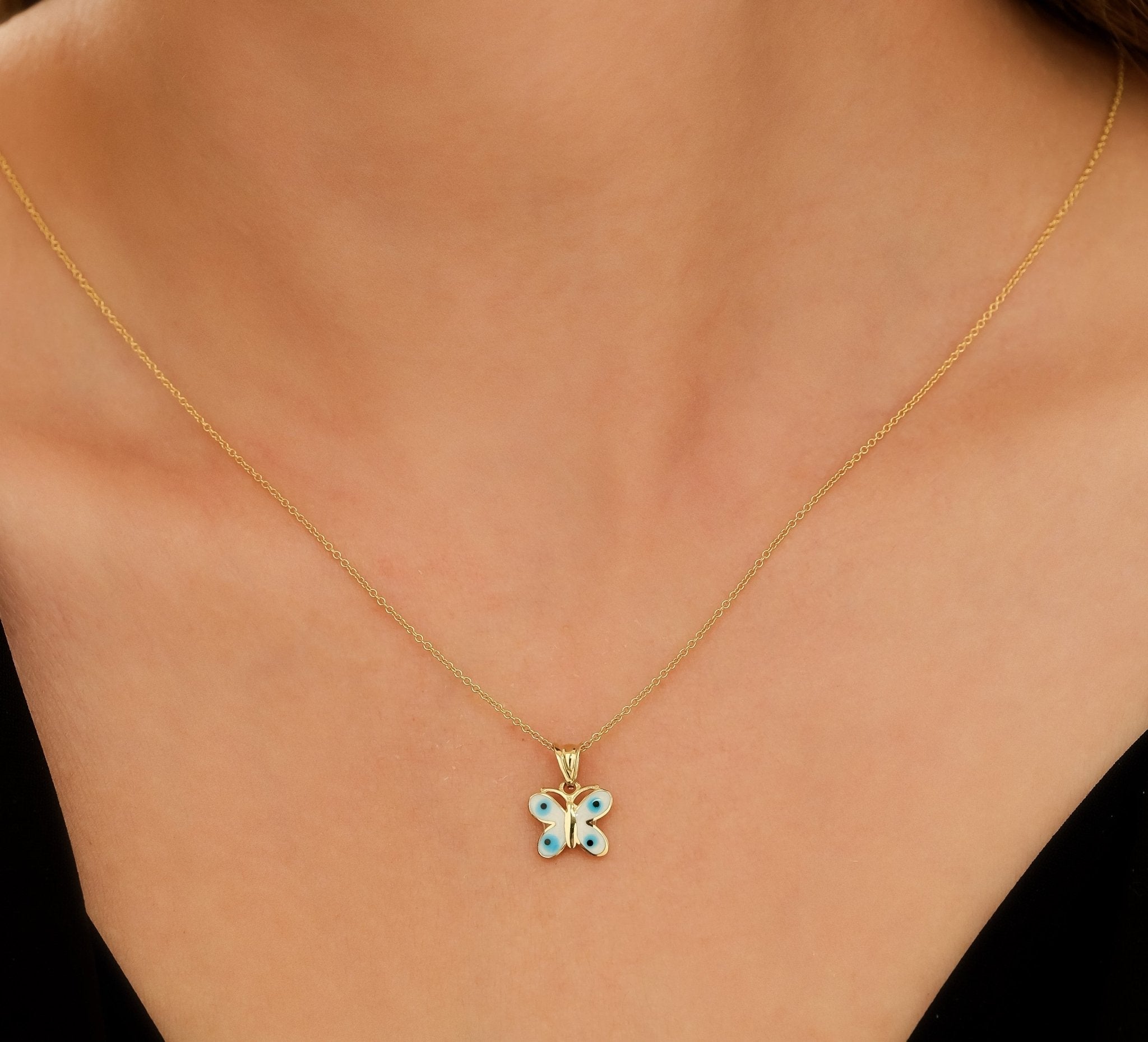 14K solid yellow gold butterfly pendant necklace worn on a model, showcasing its delicate and classy design.