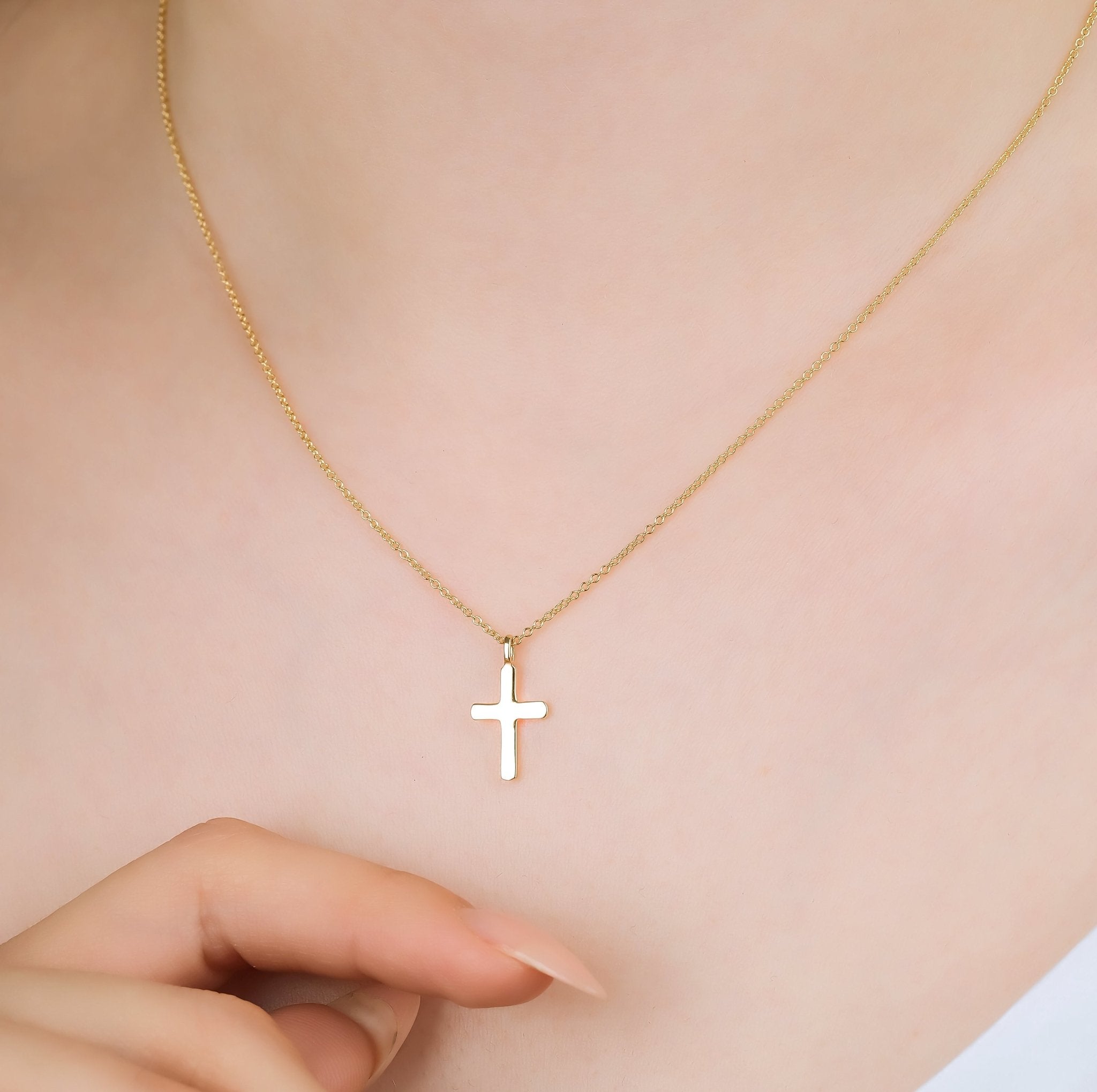 14K solid yellow gold dainty cross necklace worn, featuring a minimalist design and 16-inch chain length.
