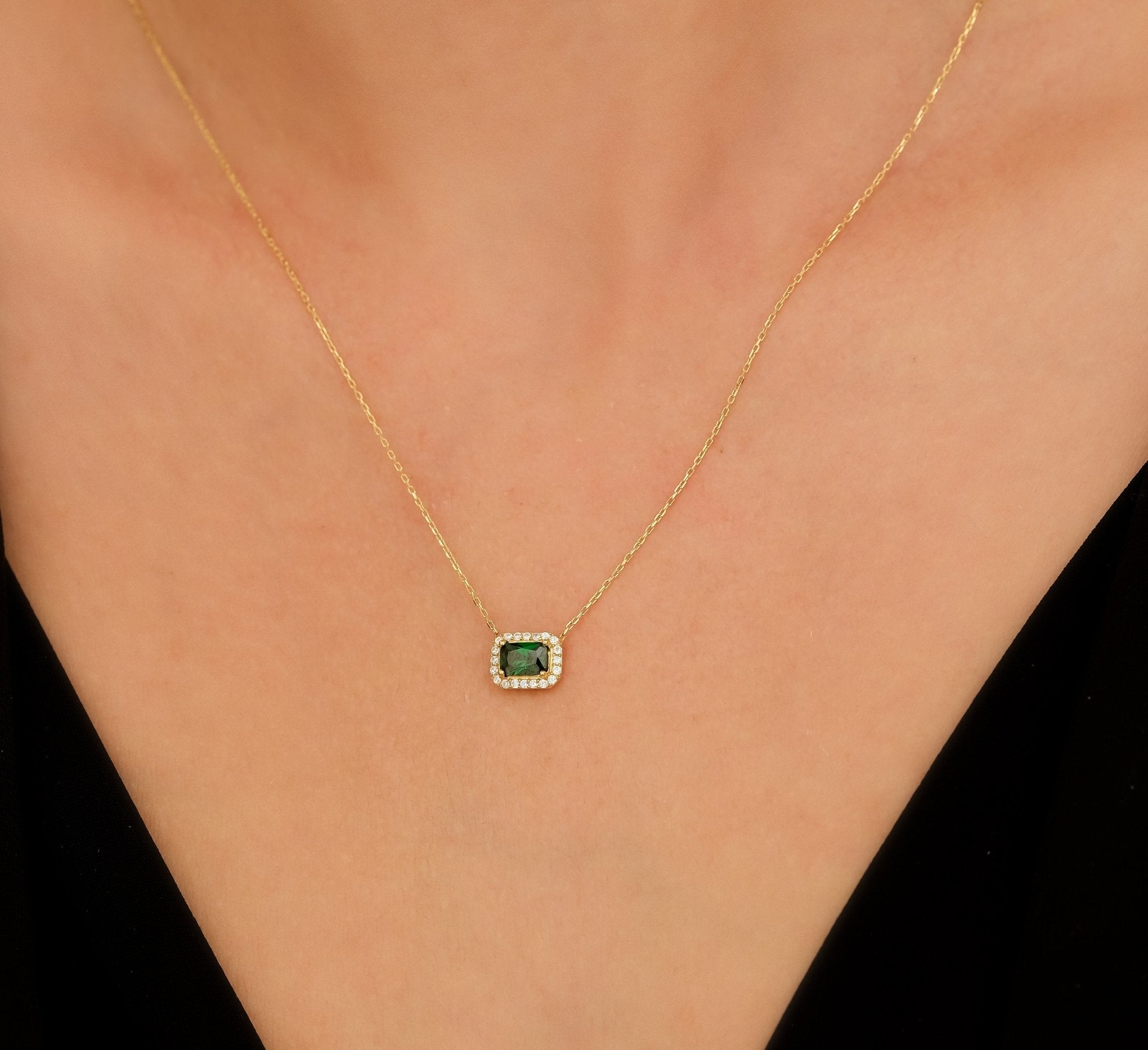14K solid yellow gold emerald cut solitaire necklace with CZ on a model's neck, highlighting a classy design.